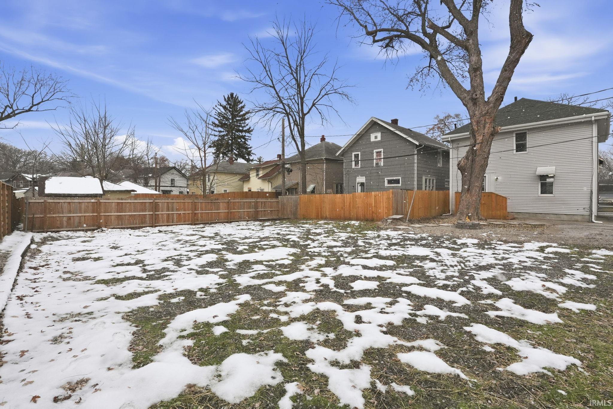 Yard covered in snow featuring a residential view