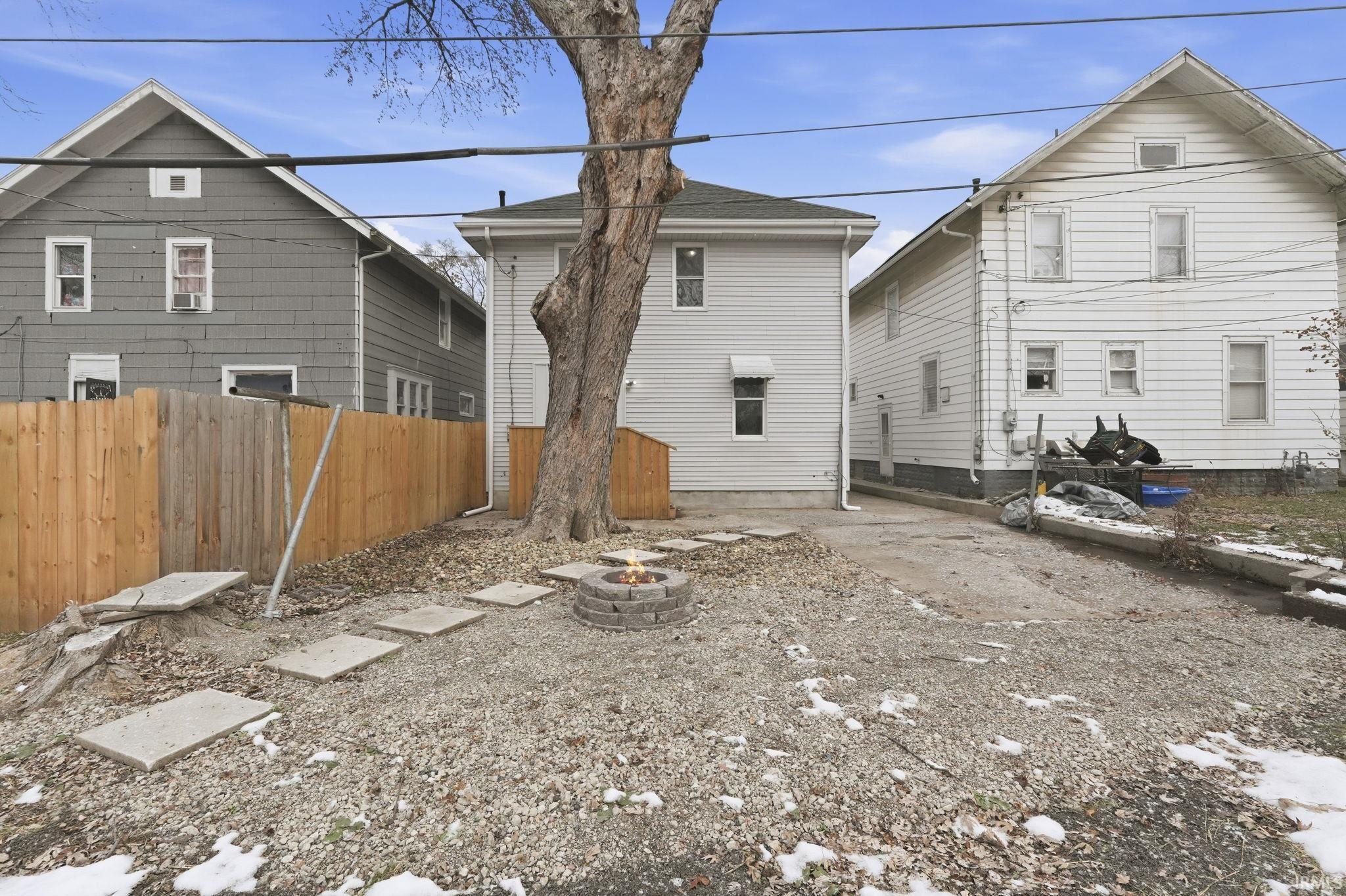 Rear view of property featuring an outdoor fire pit