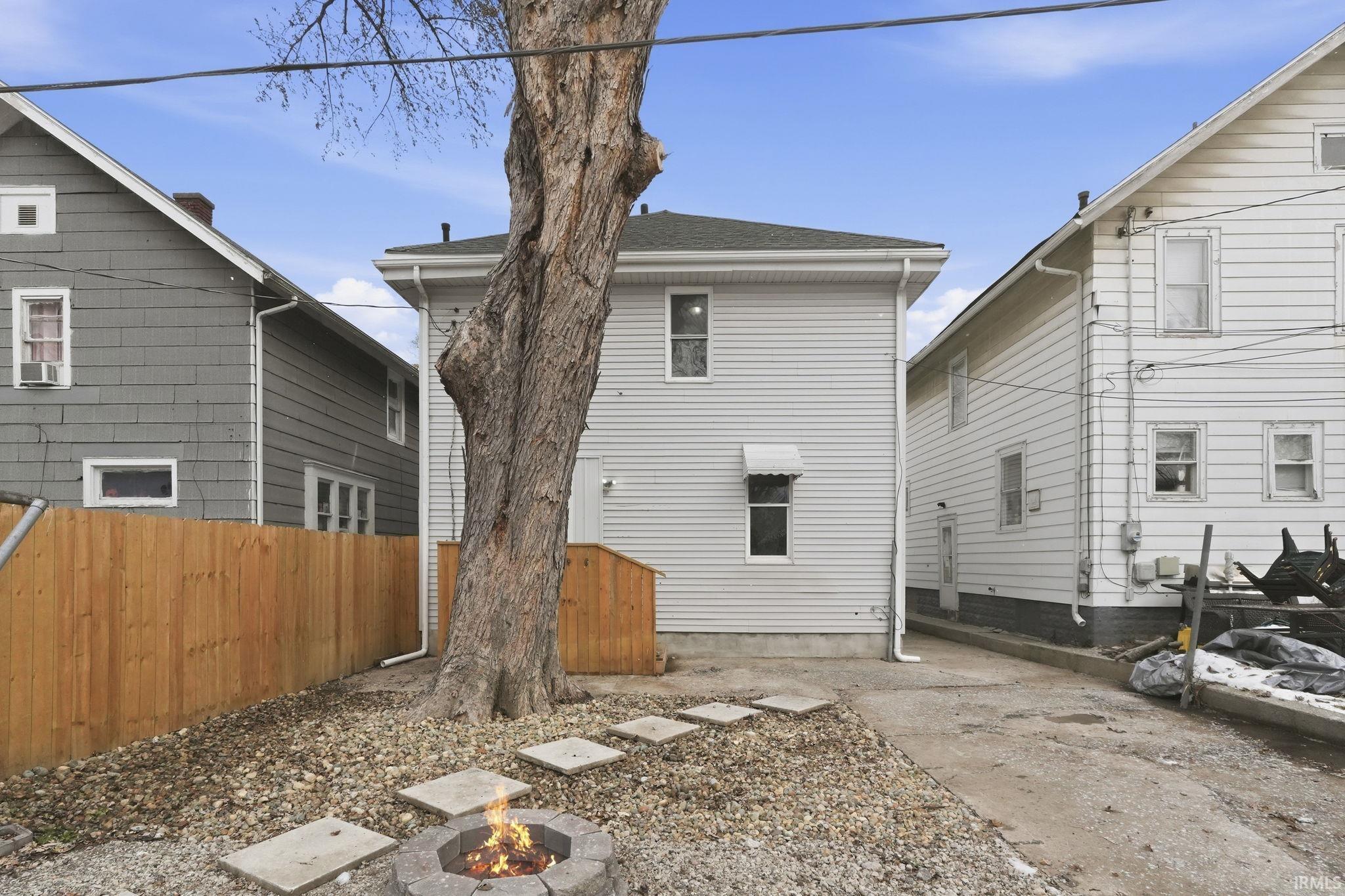 Back of property with a fire pit