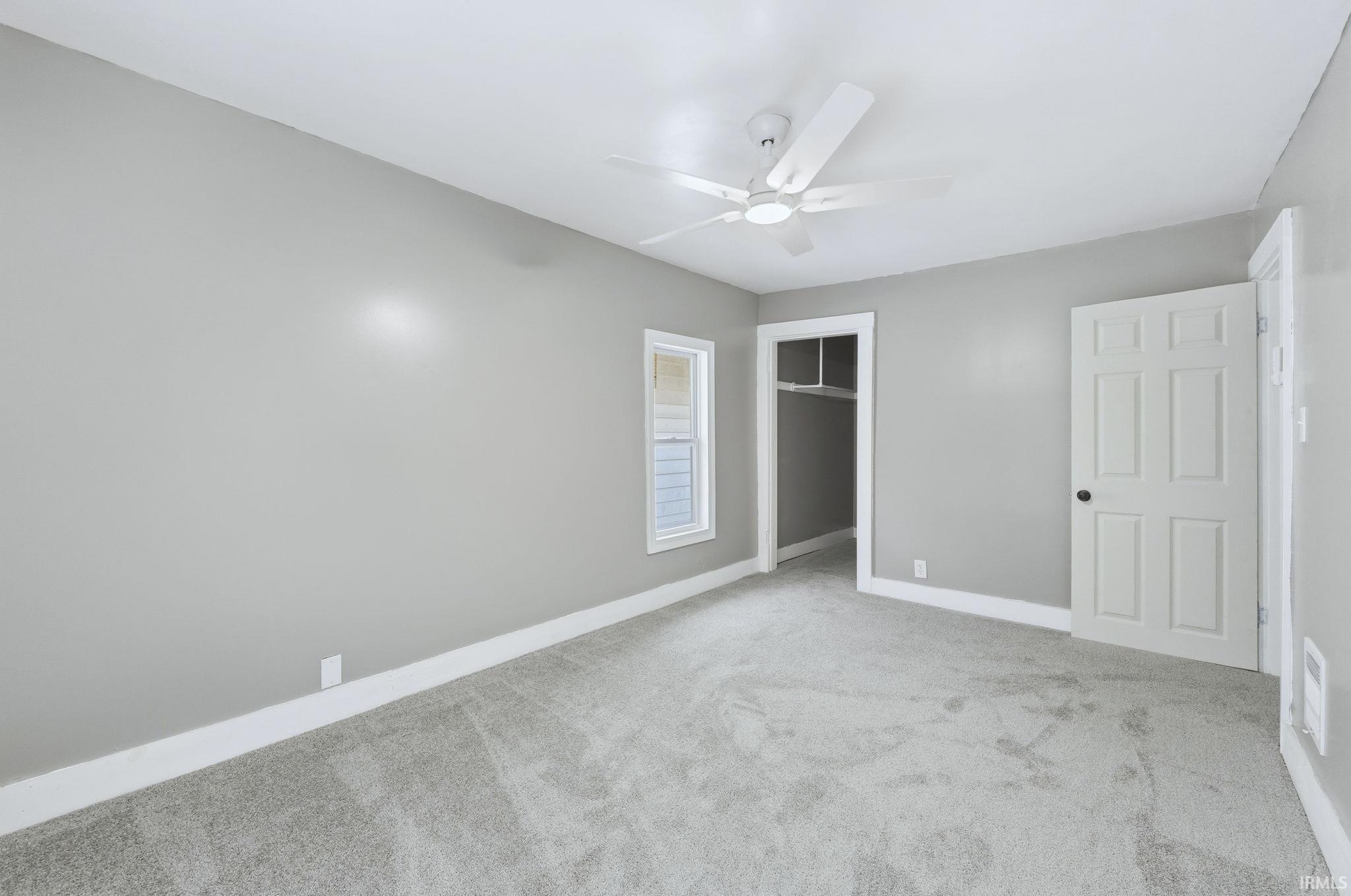 Unfurnished bedroom with light carpet, a ceiling fan, and a closet