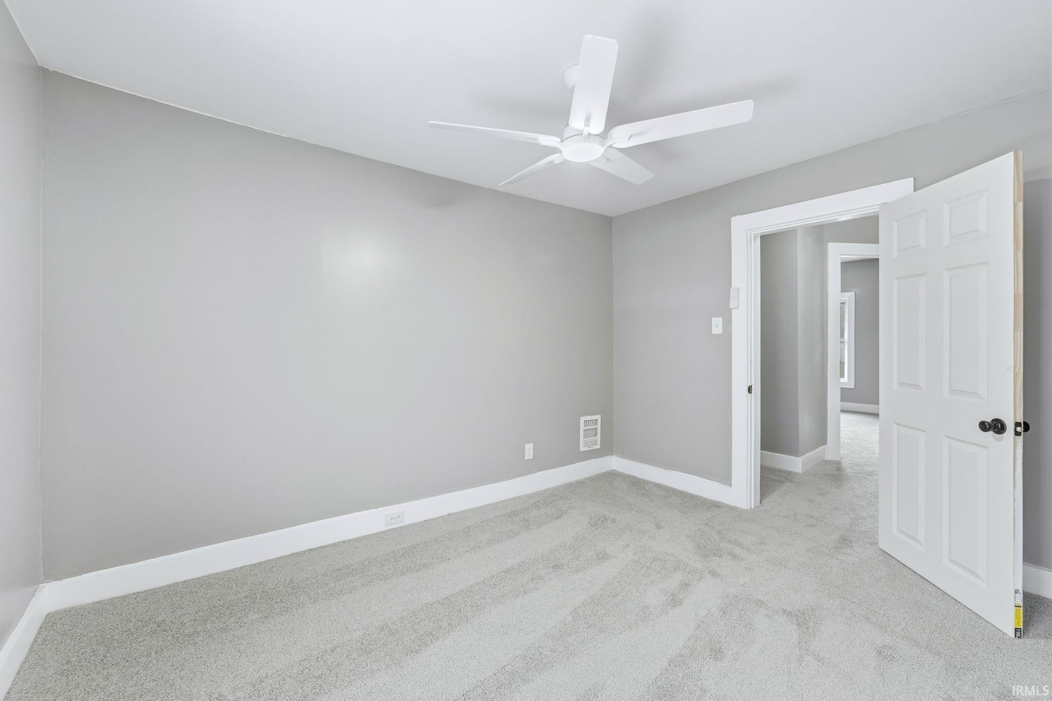 Spare room with light carpet and ceiling fan