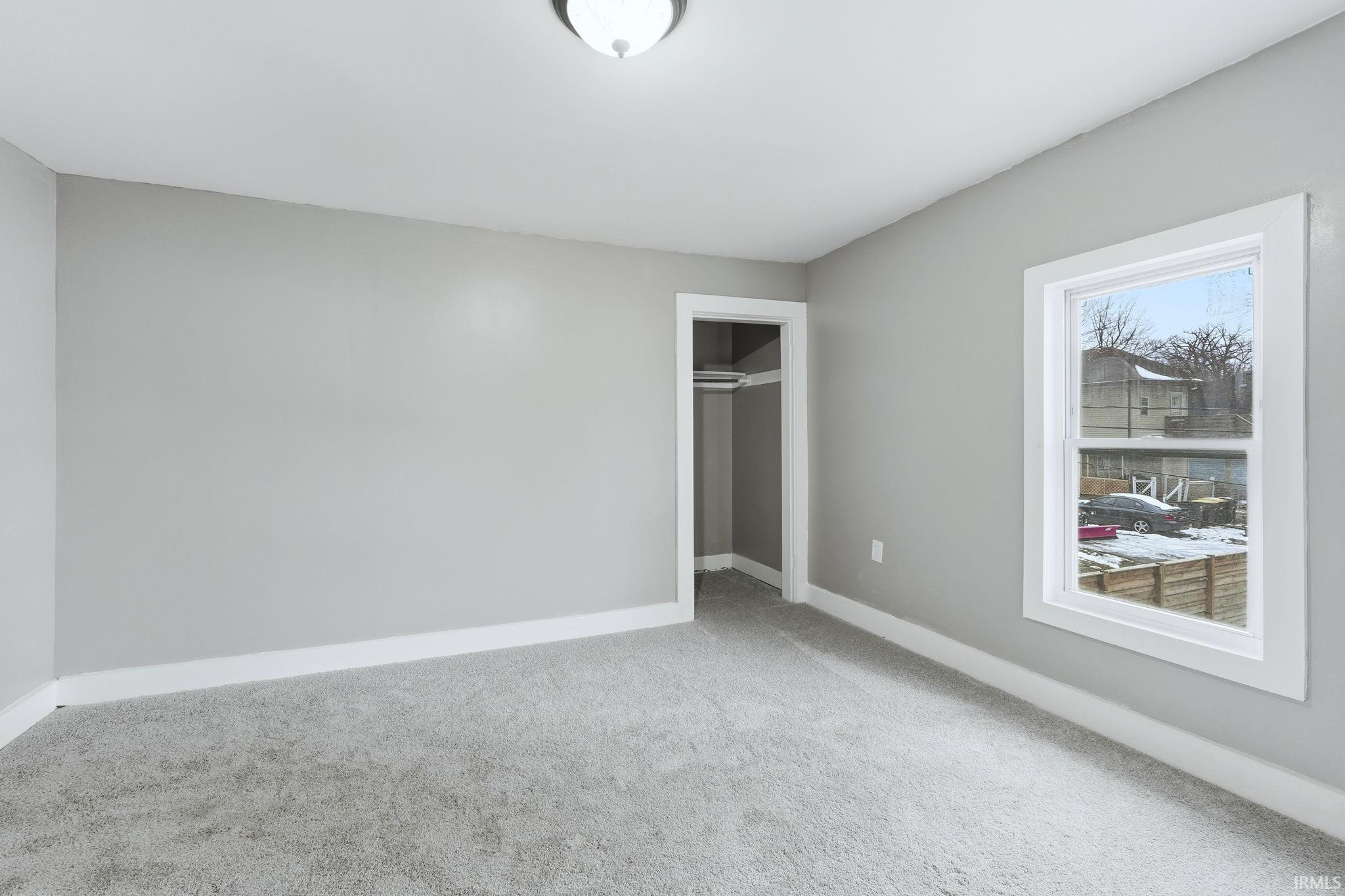 Unfurnished bedroom featuring a closet and light colored carpet