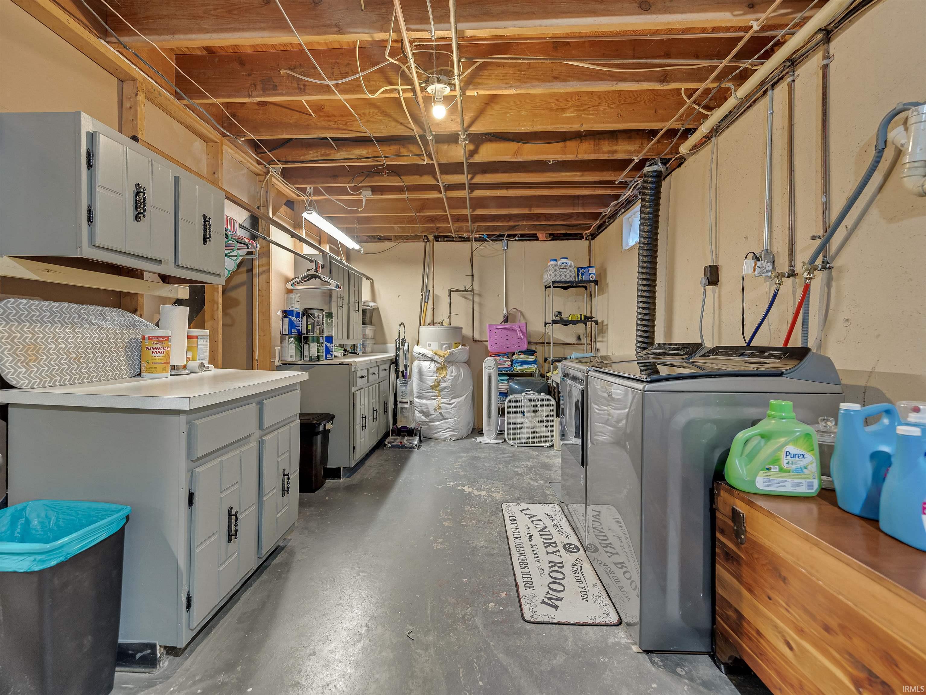 Unfinished below grade area featuring separate washer and dryer and water heater