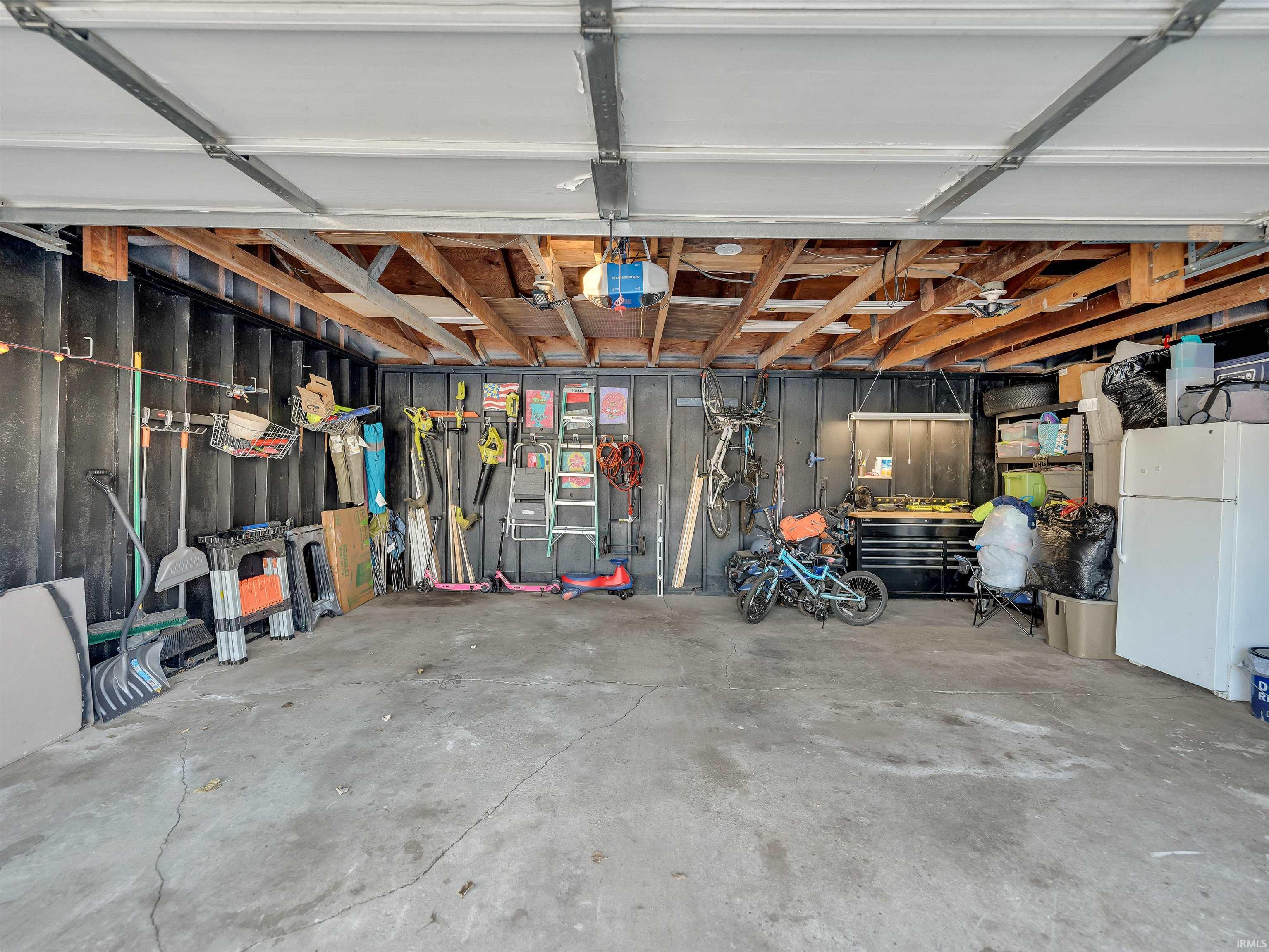 Garage with freestanding refrigerator and a garage door opener