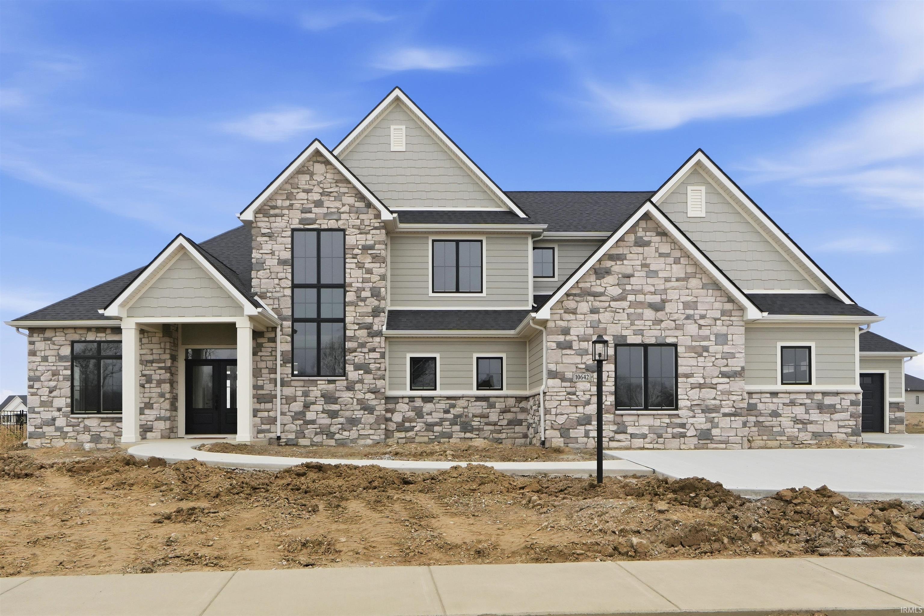 Craftsman-style home featuring stone siding and roof with shingles