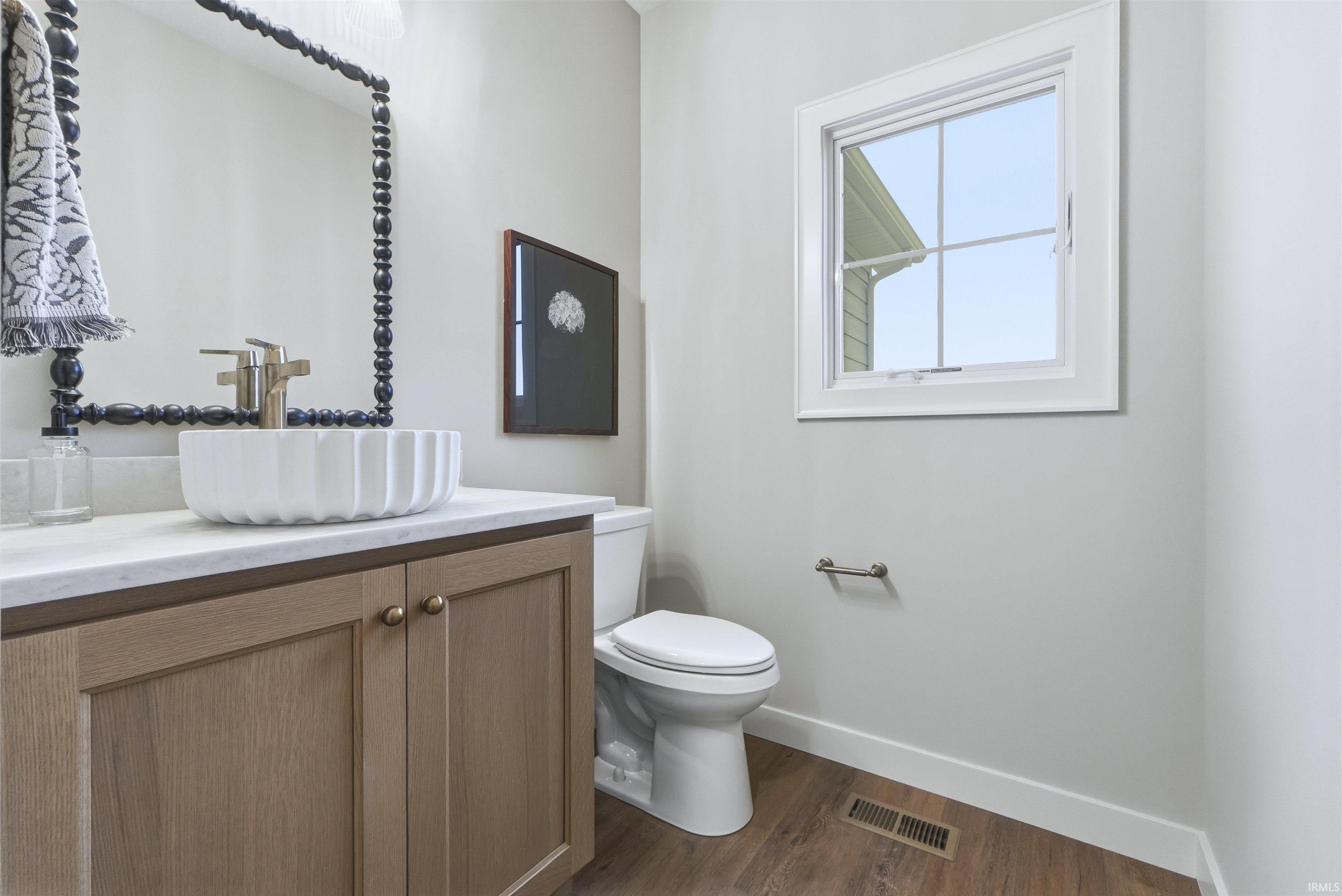 Half bath featuring vanity and dark wood finished floors