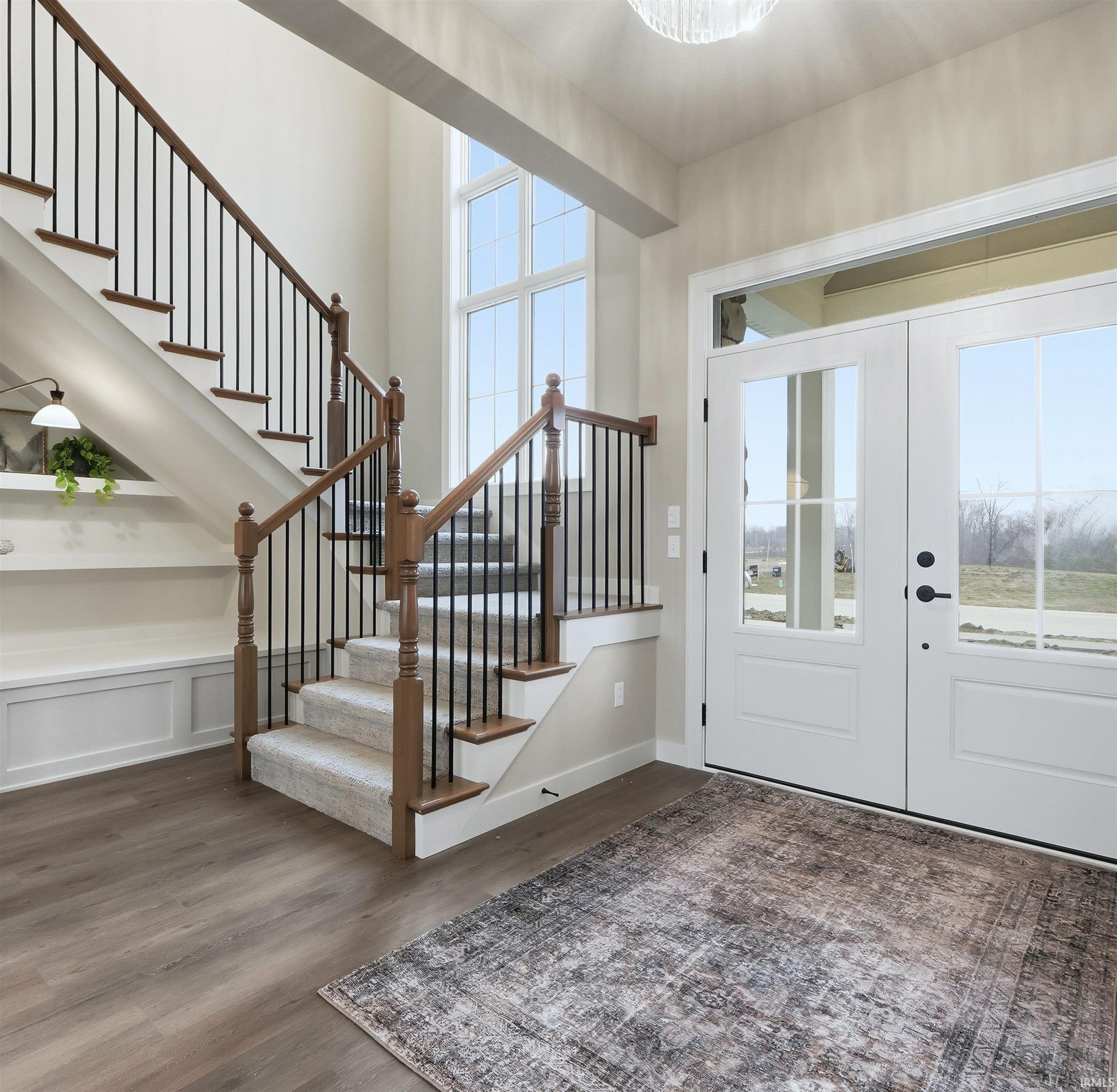 Foyer featuring french doors, dark wood-type flooring, and stairway