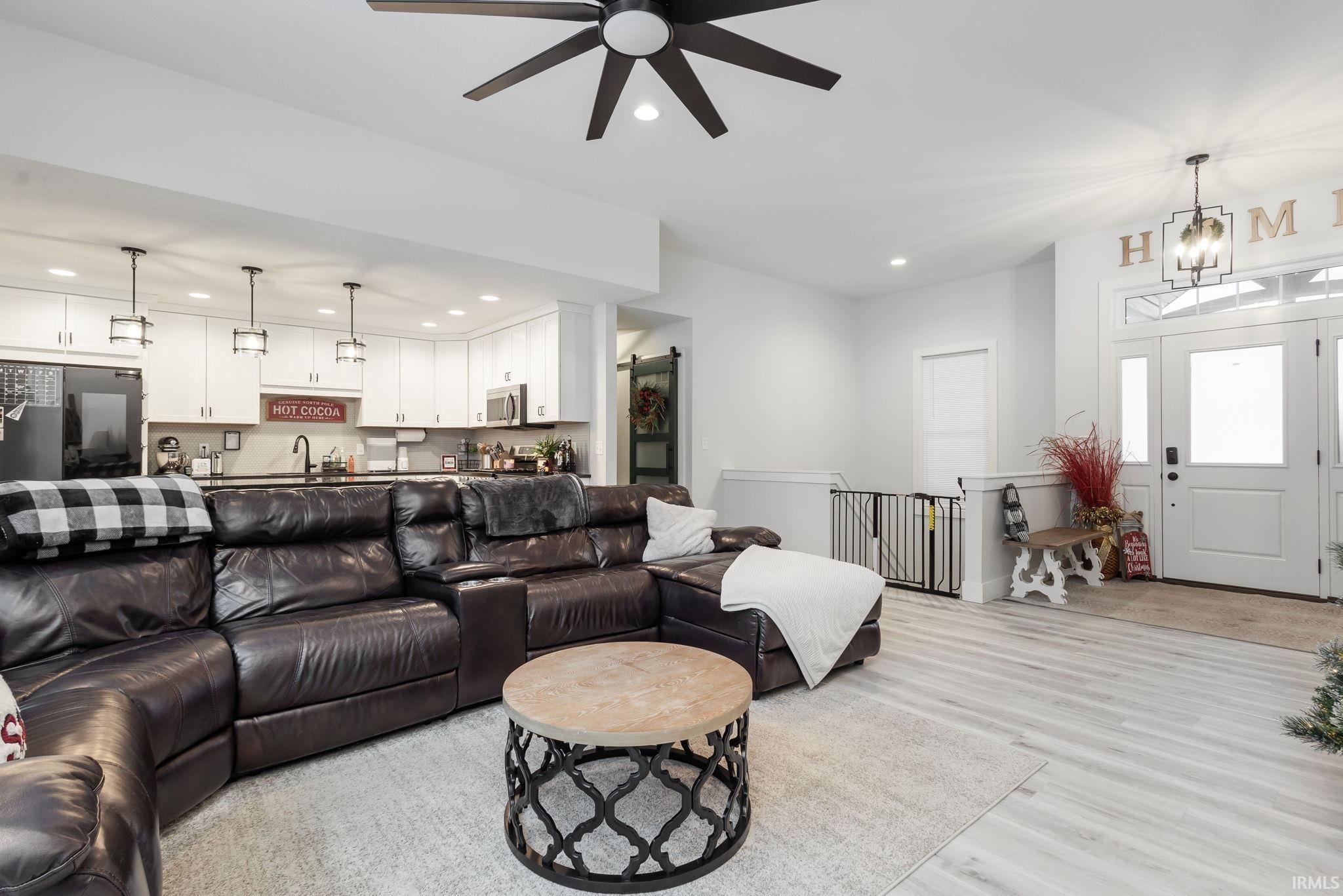Living area with light wood-type flooring, ceiling fan, and recessed lighting