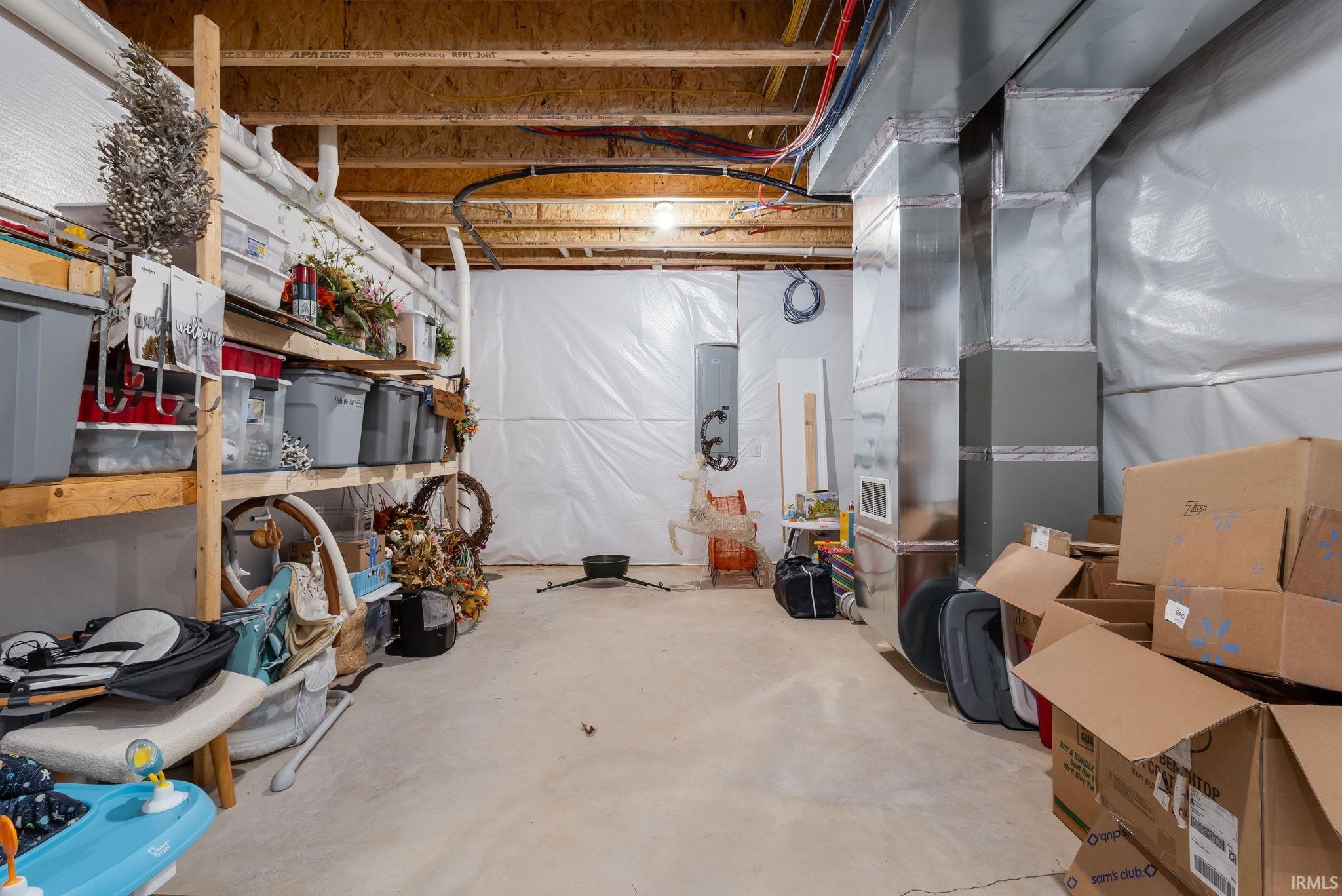 Unfinished basement with heating unit and electric panel