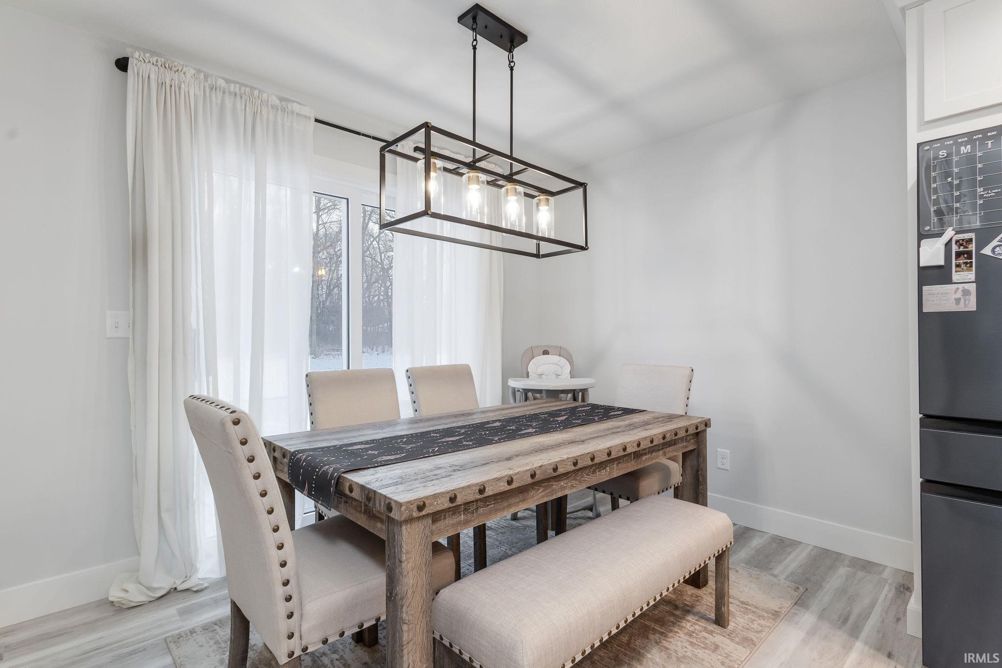 Dining room with light wood-type flooring and baseboards