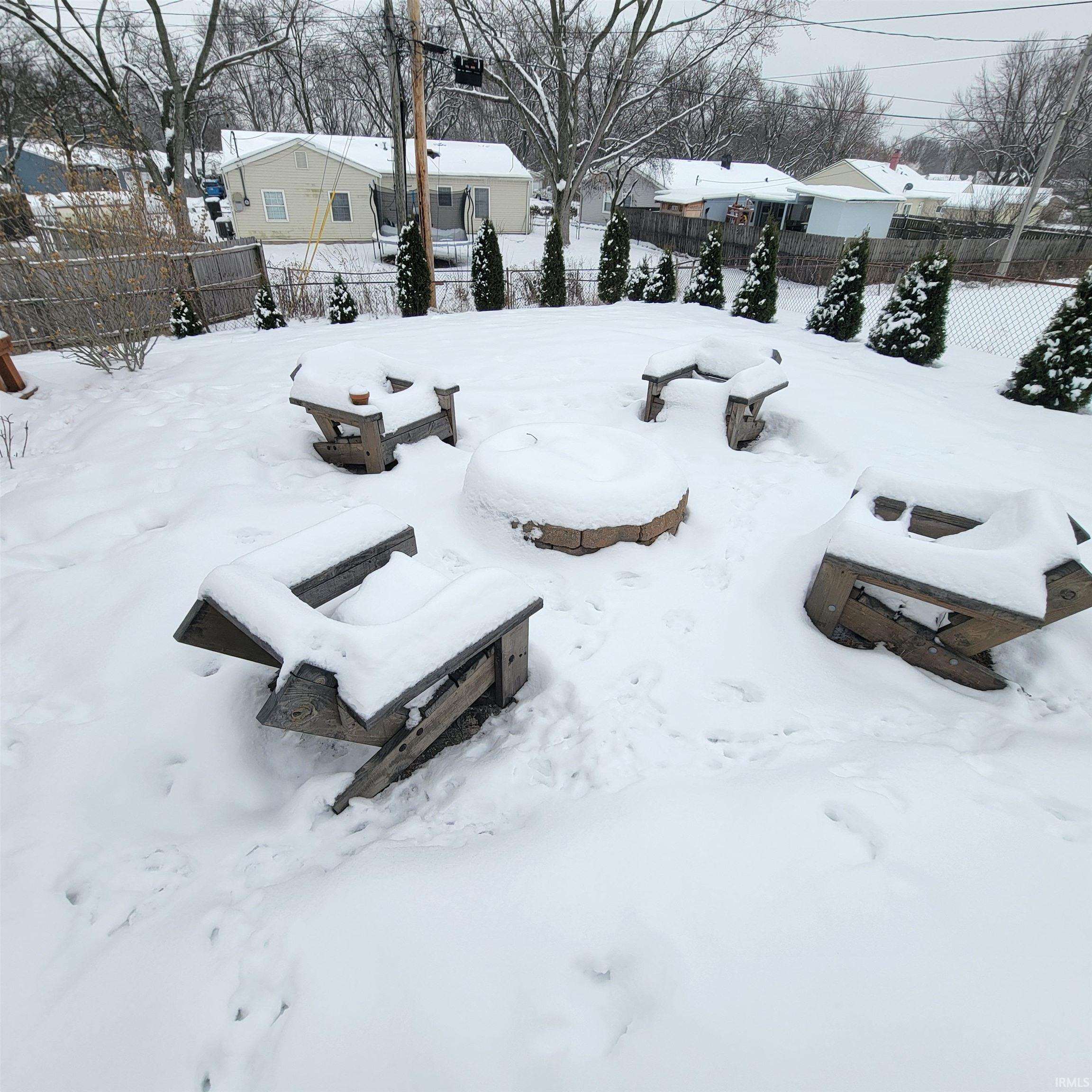 Yard layered in snow featuring a fenced backyard