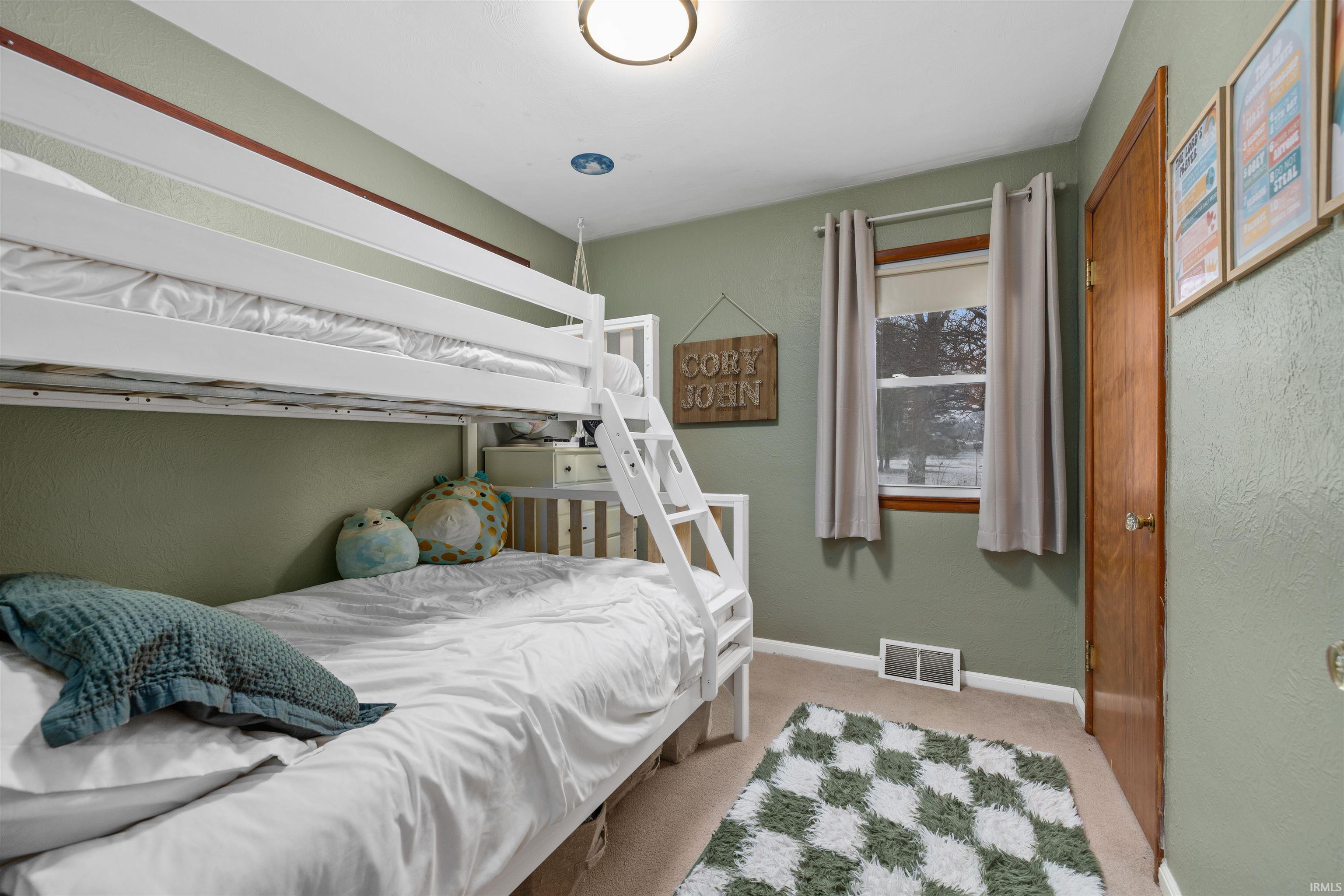 Carpeted bedroom with a textured wall