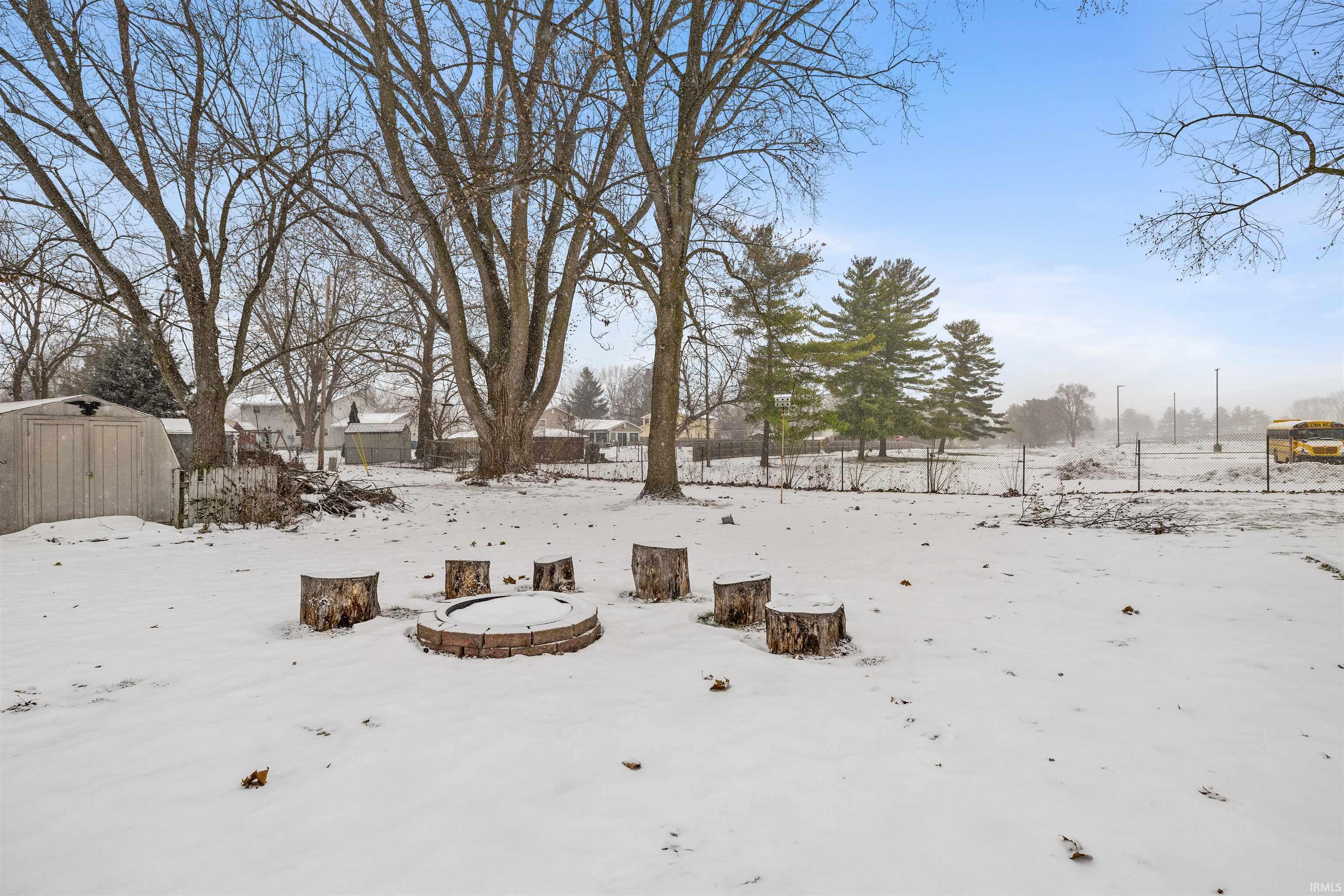 Snowy yard featuring a storage unit