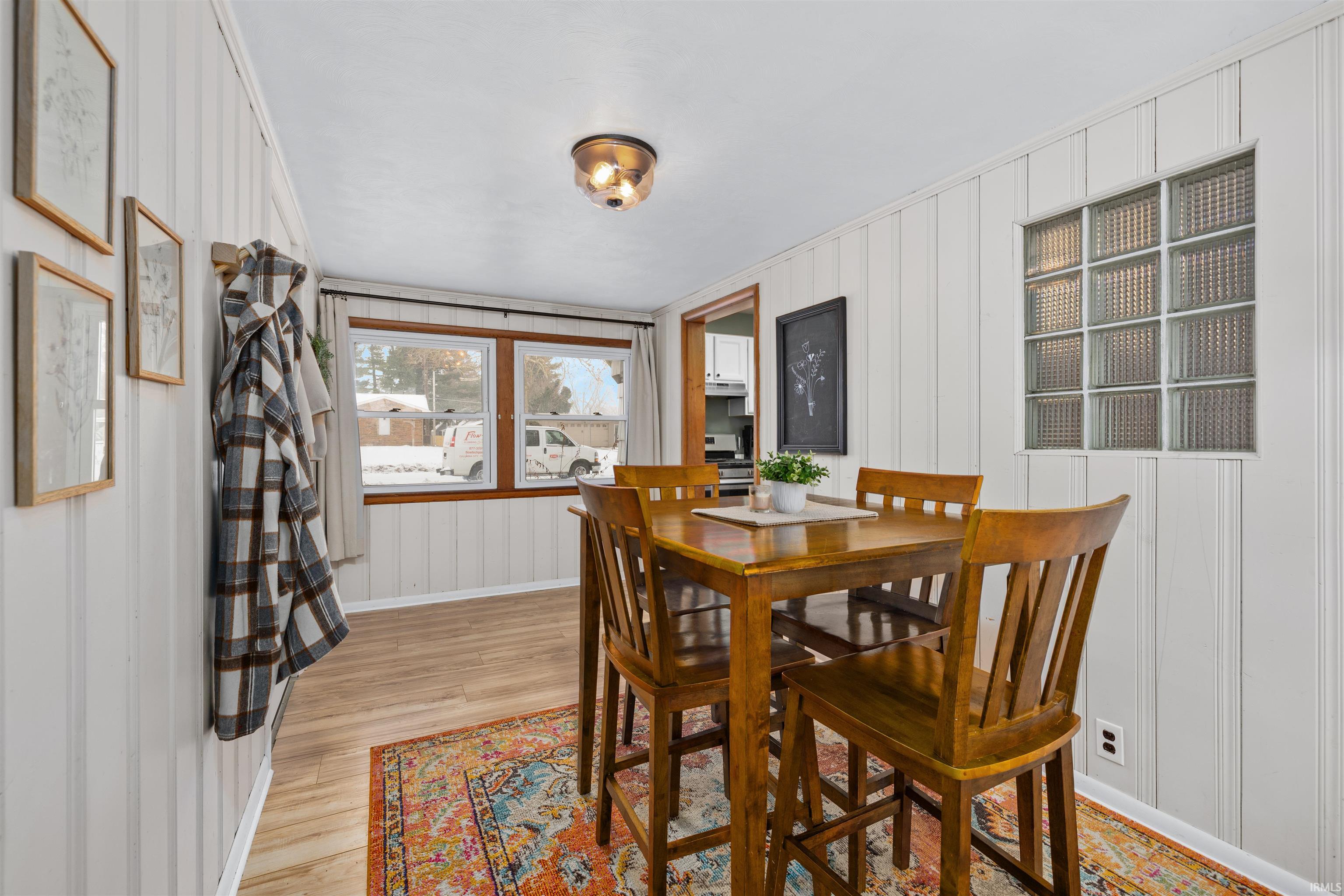 Dining space featuring a decorative wall and light wood-style floors