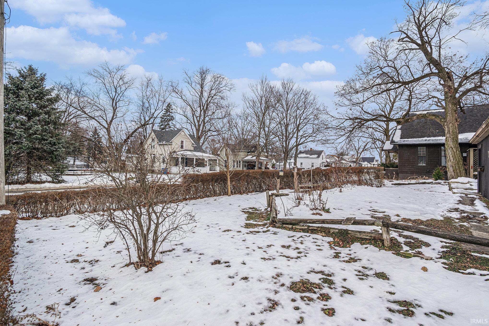 Yard covered in snow featuring a residential view