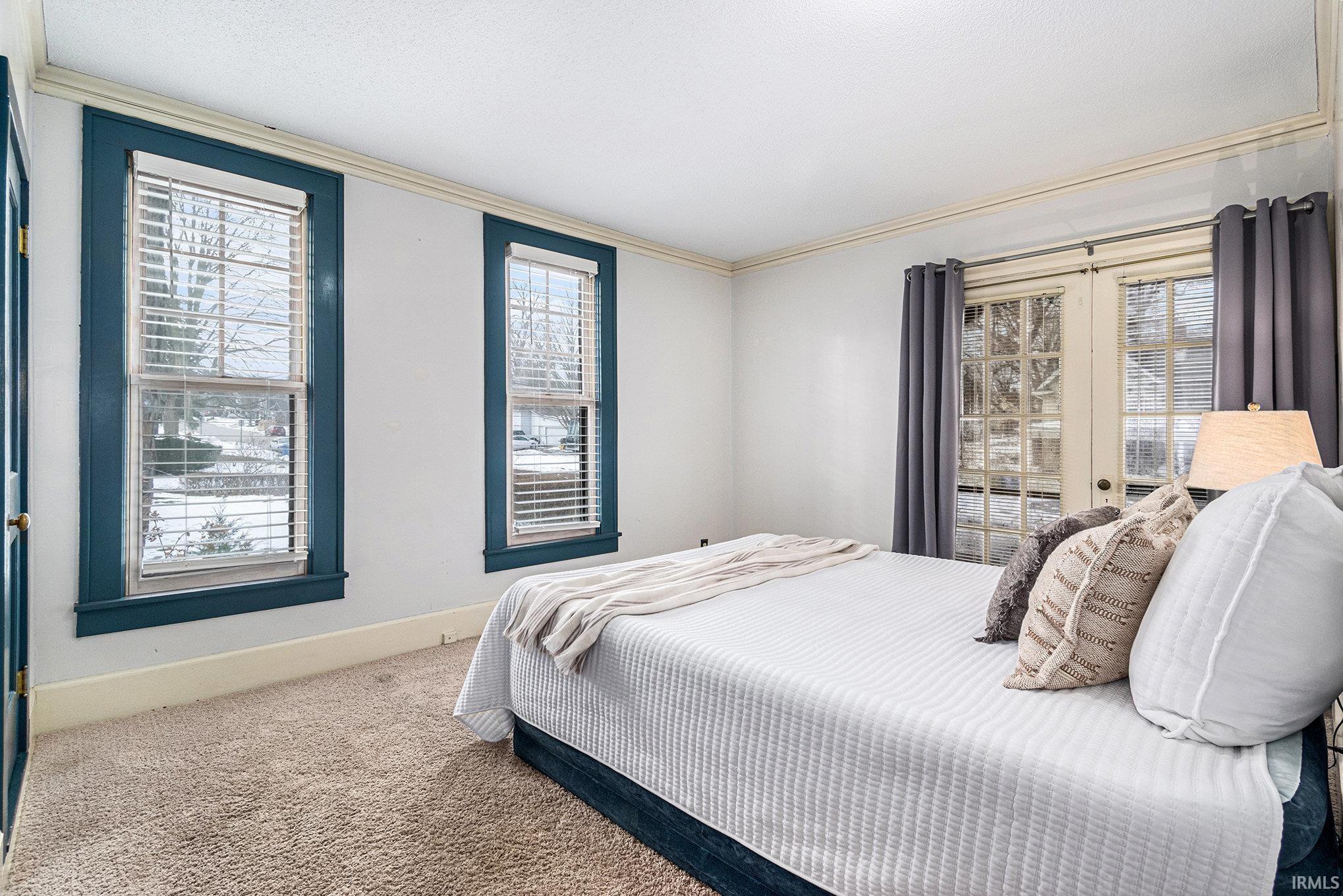 Carpeted bedroom with baseboards and french doors