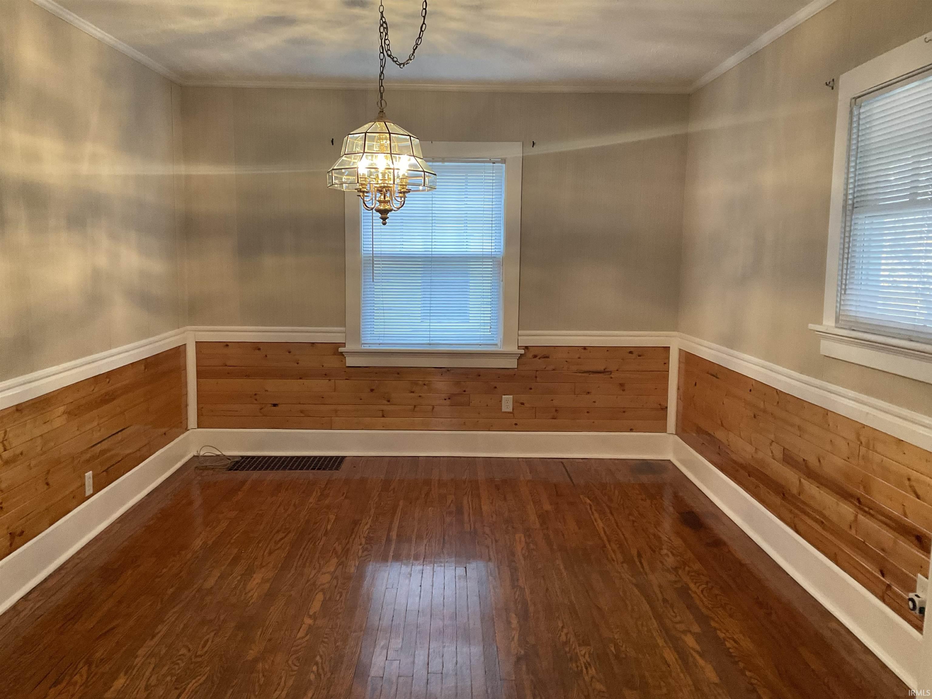 Dining area with wainscoting, hardwood floors