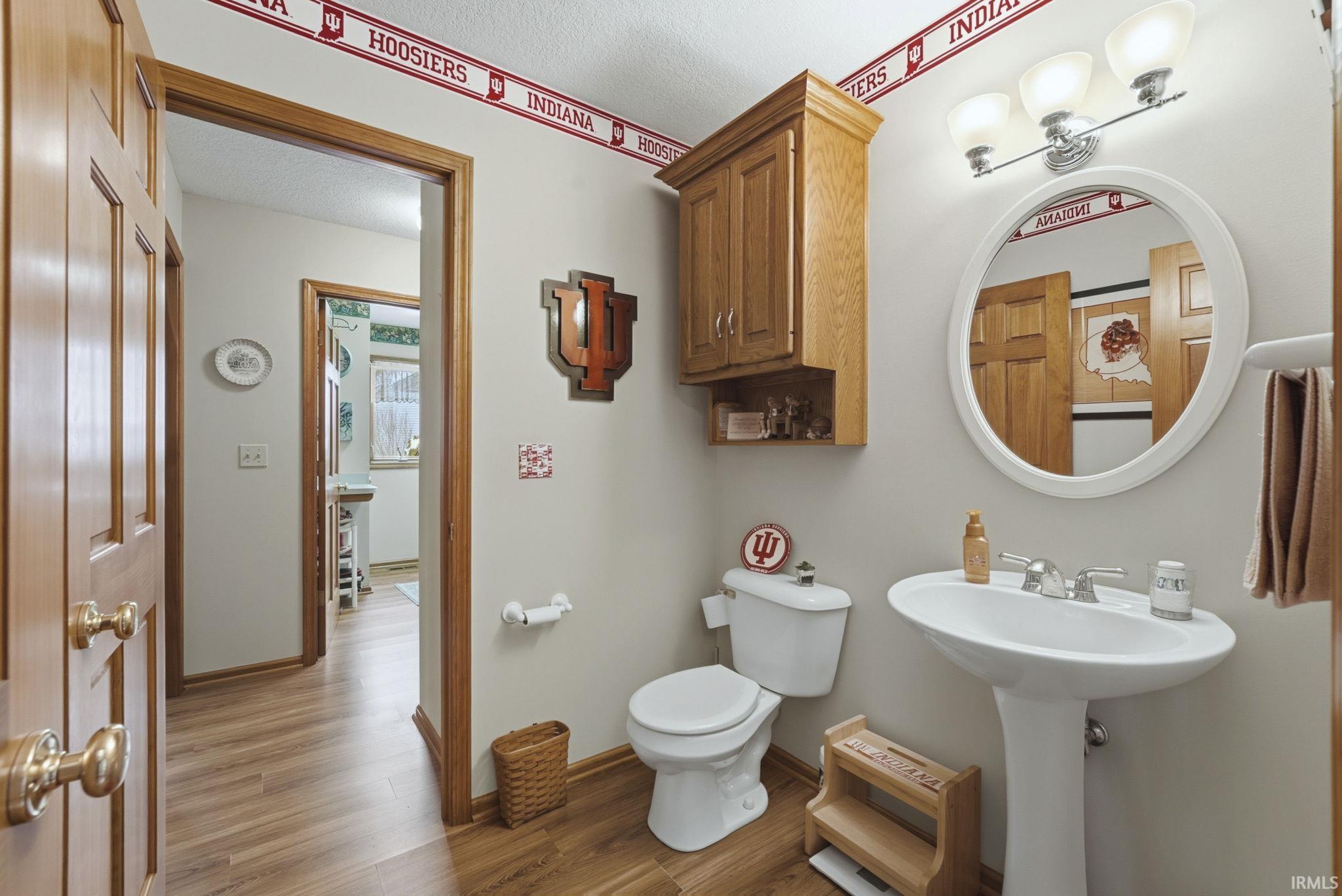 Bathroom with toilet and light wood-style flooring