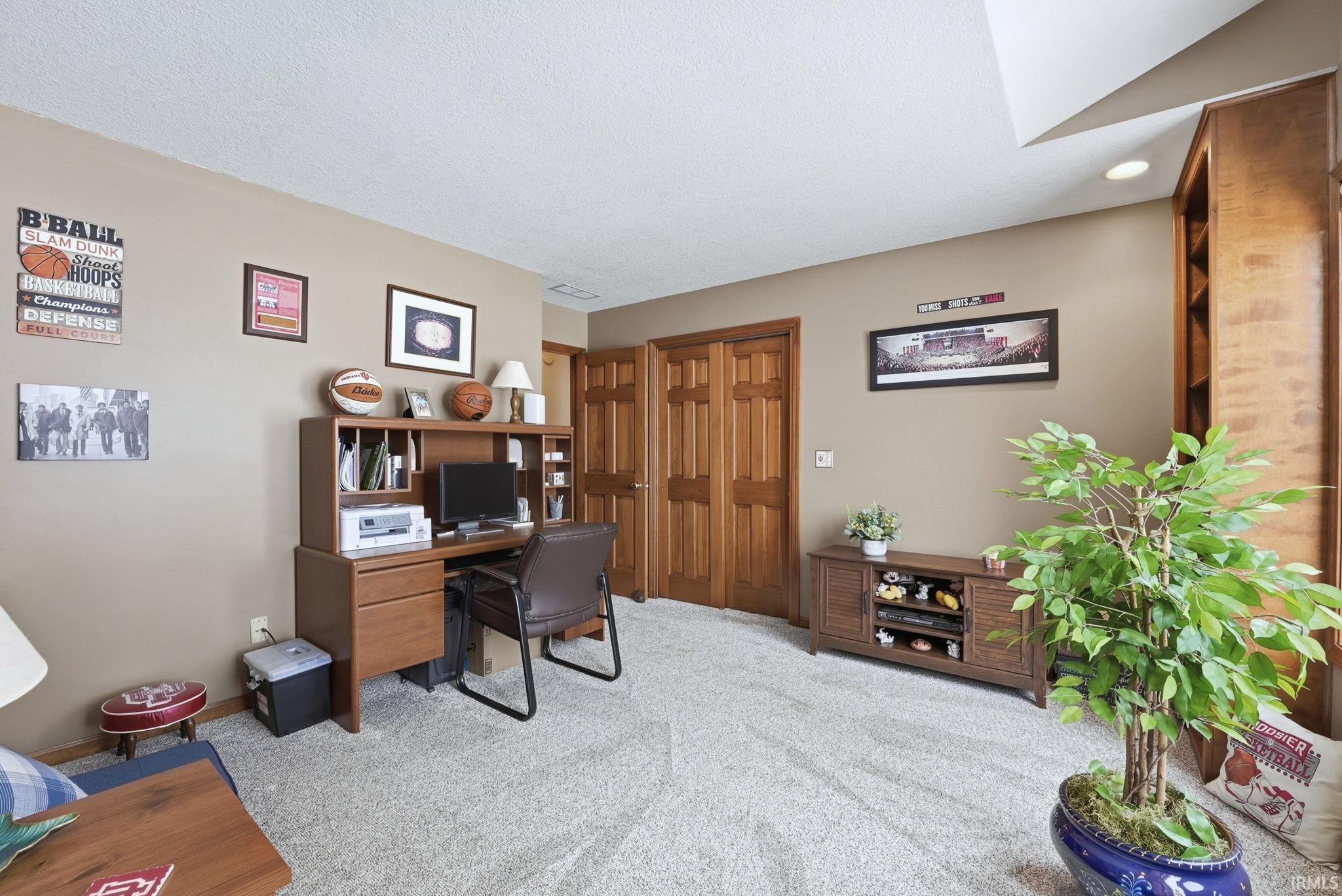 Office space featuring light carpet and a textured ceiling
