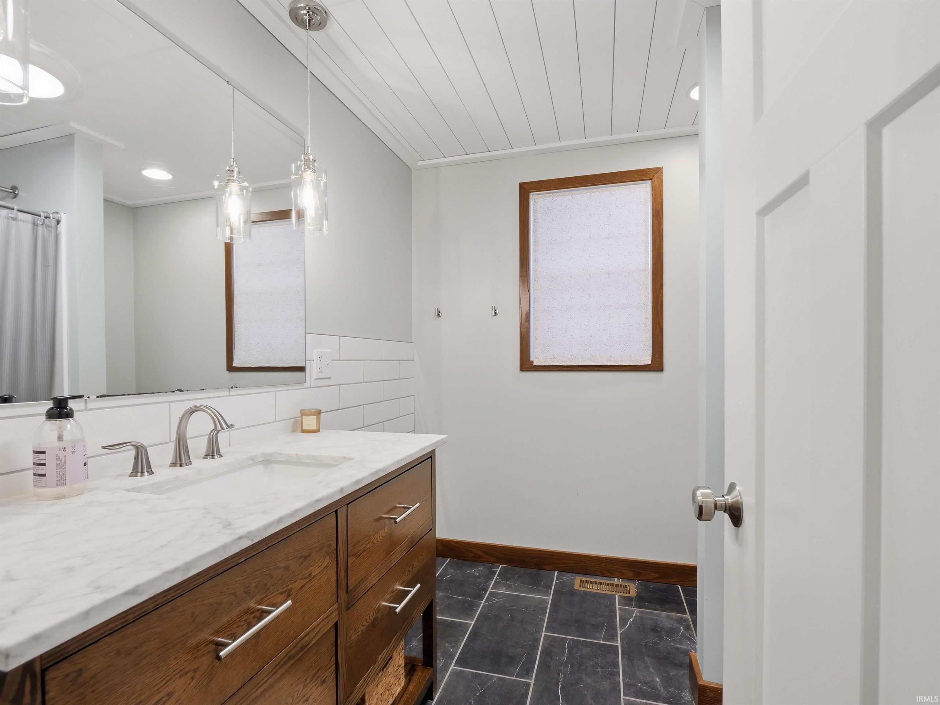 Full bathroom featuring vanity, subway tile backsplash, a shower with shower curtain, and recessed lighting