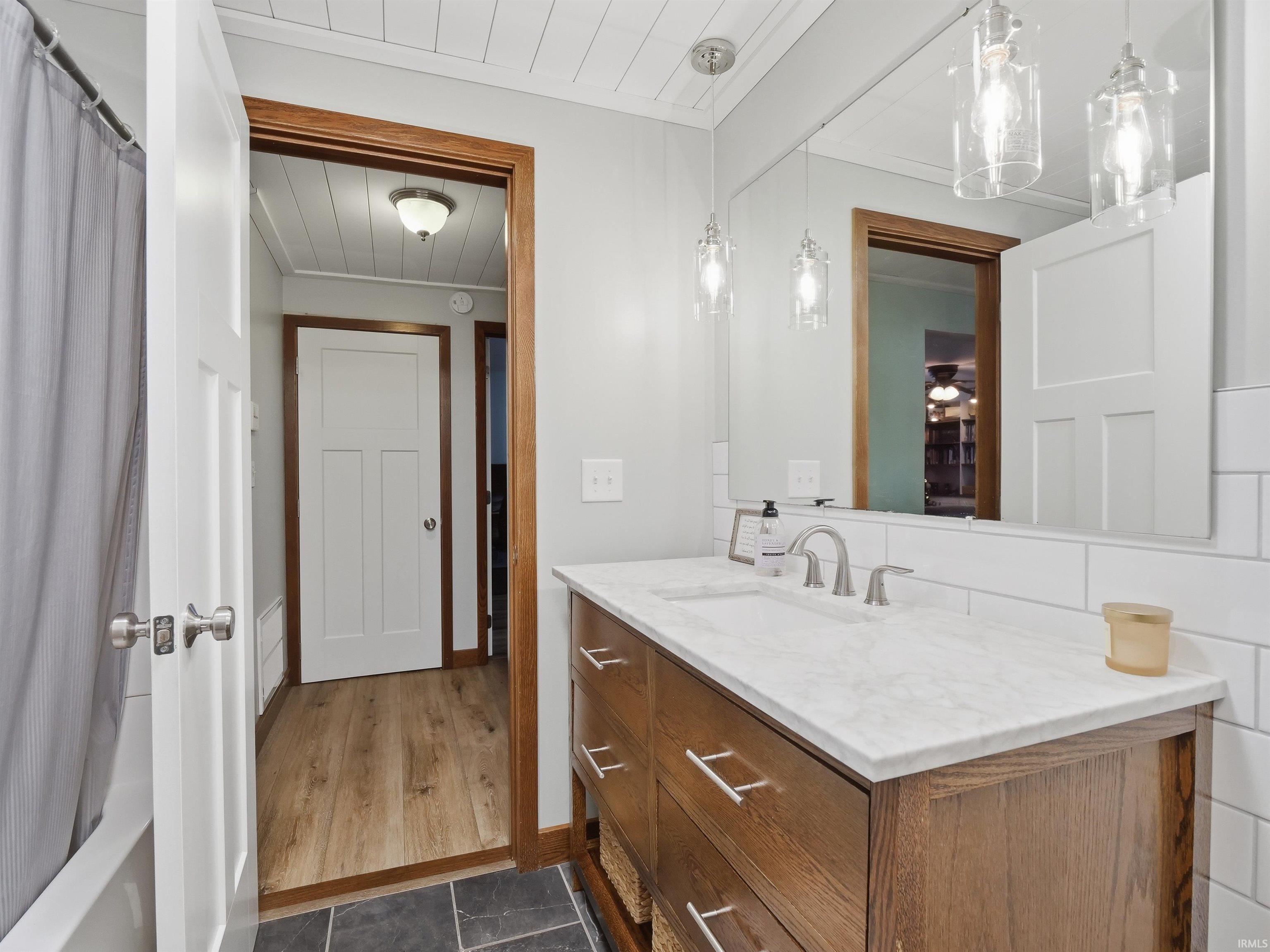Full bath featuring vanity and shower / tub combo with curtain
