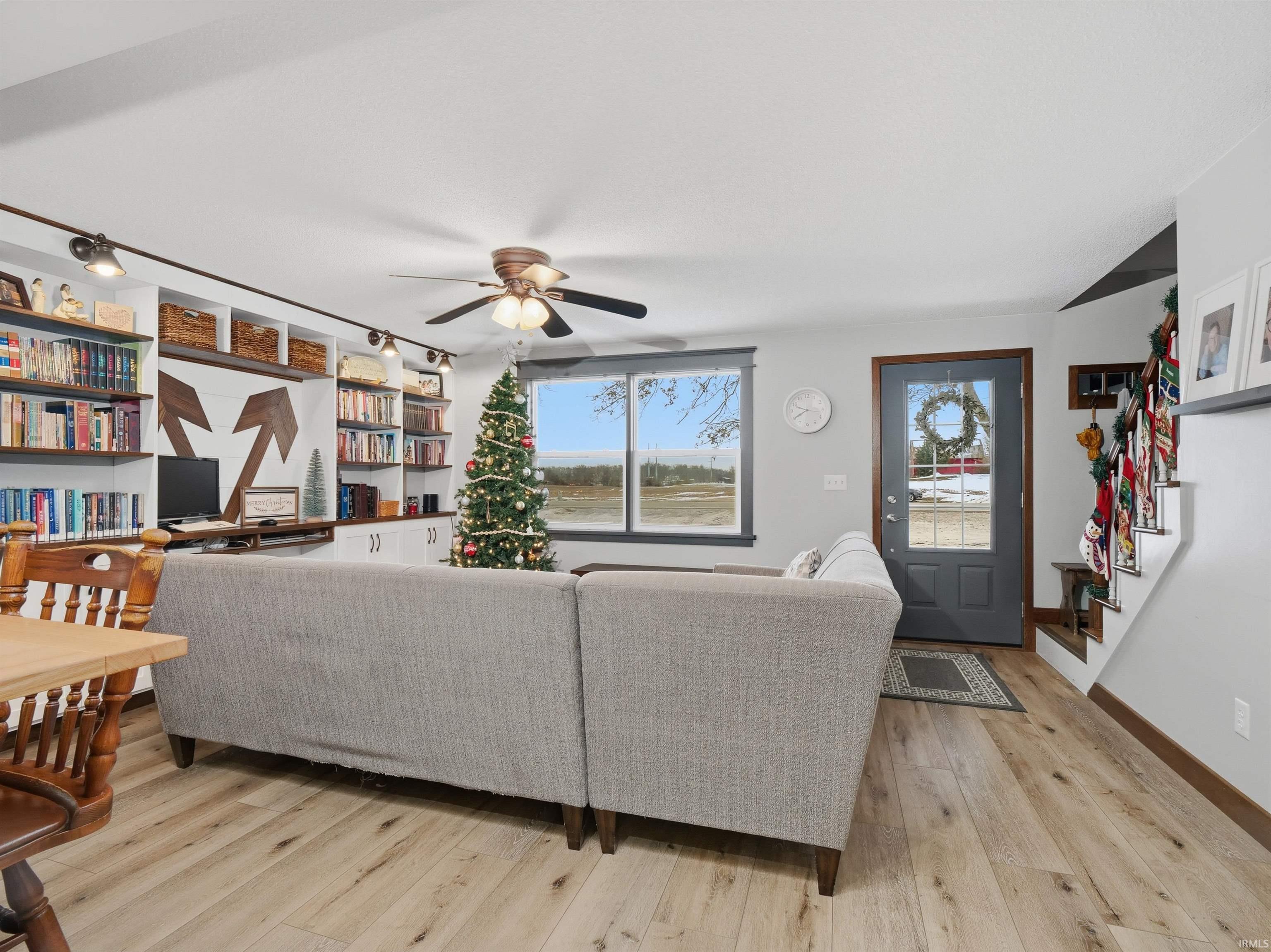 Living room with light wood-style flooring and stairway