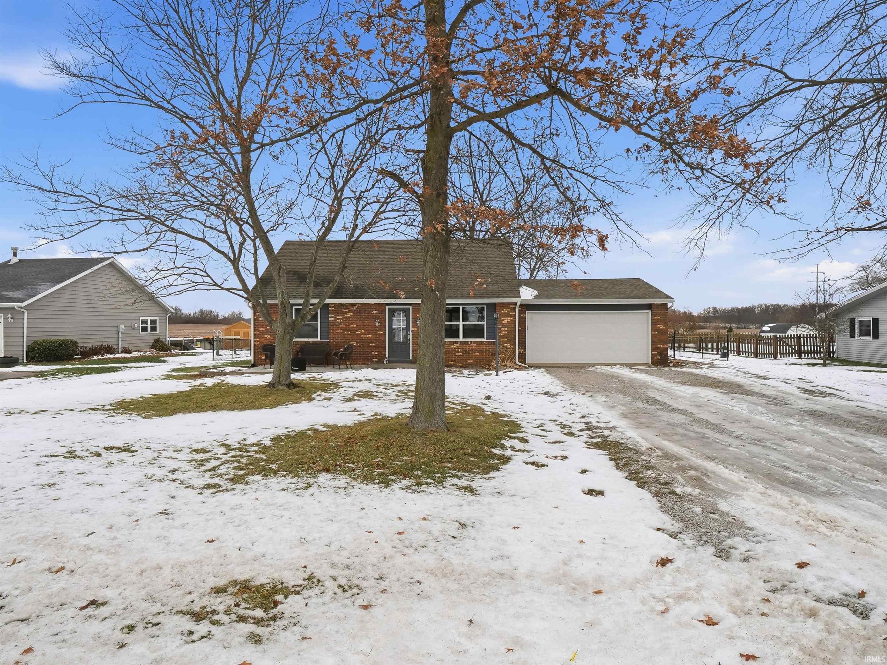 View of front of house featuring brick siding, a shingled roof, and a garage