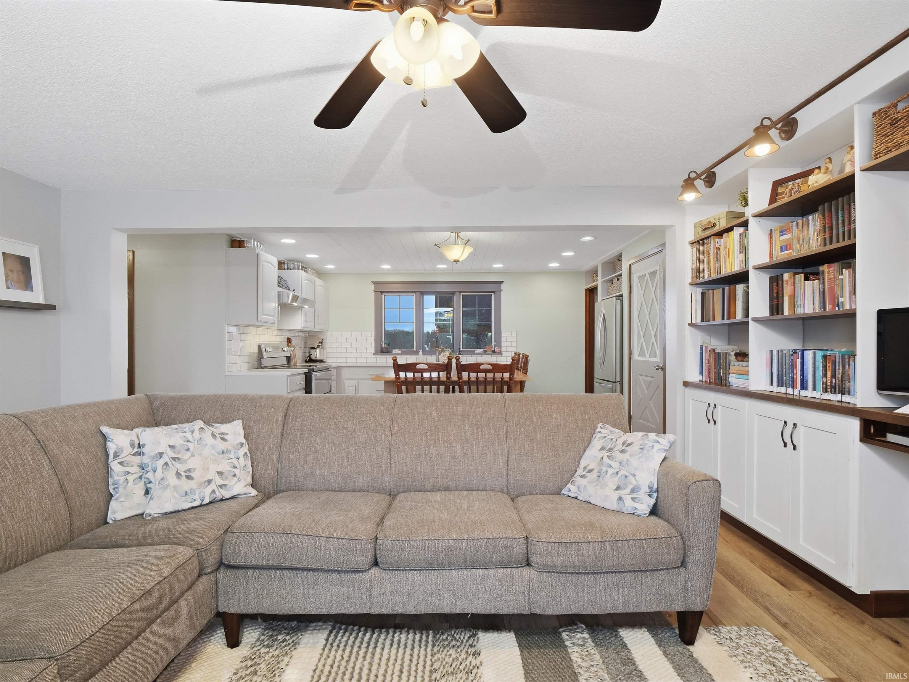 Living area with light wood-style floors and ceiling fan