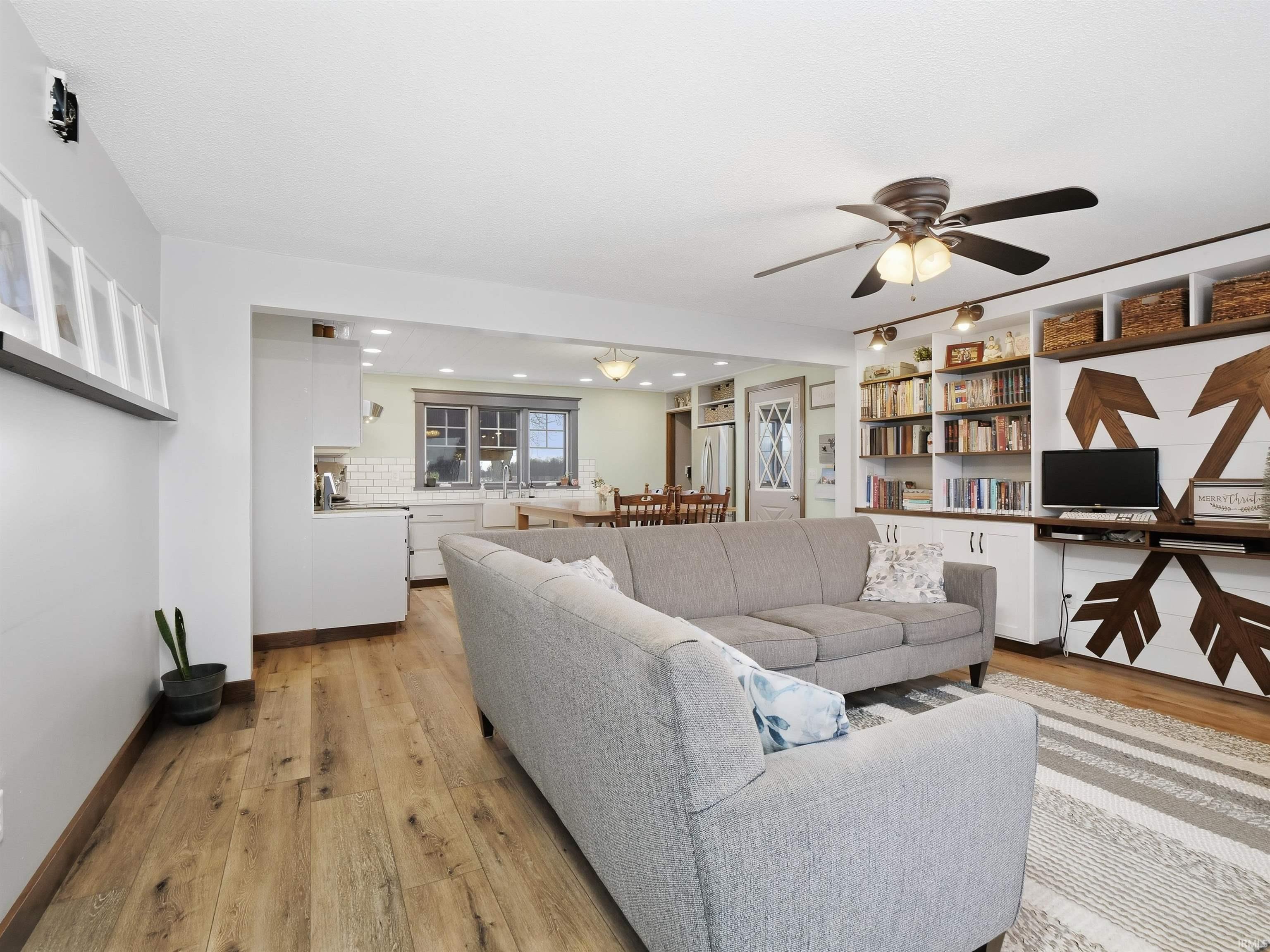 Living area featuring light wood-type flooring, ceiling fan, and recessed lighting