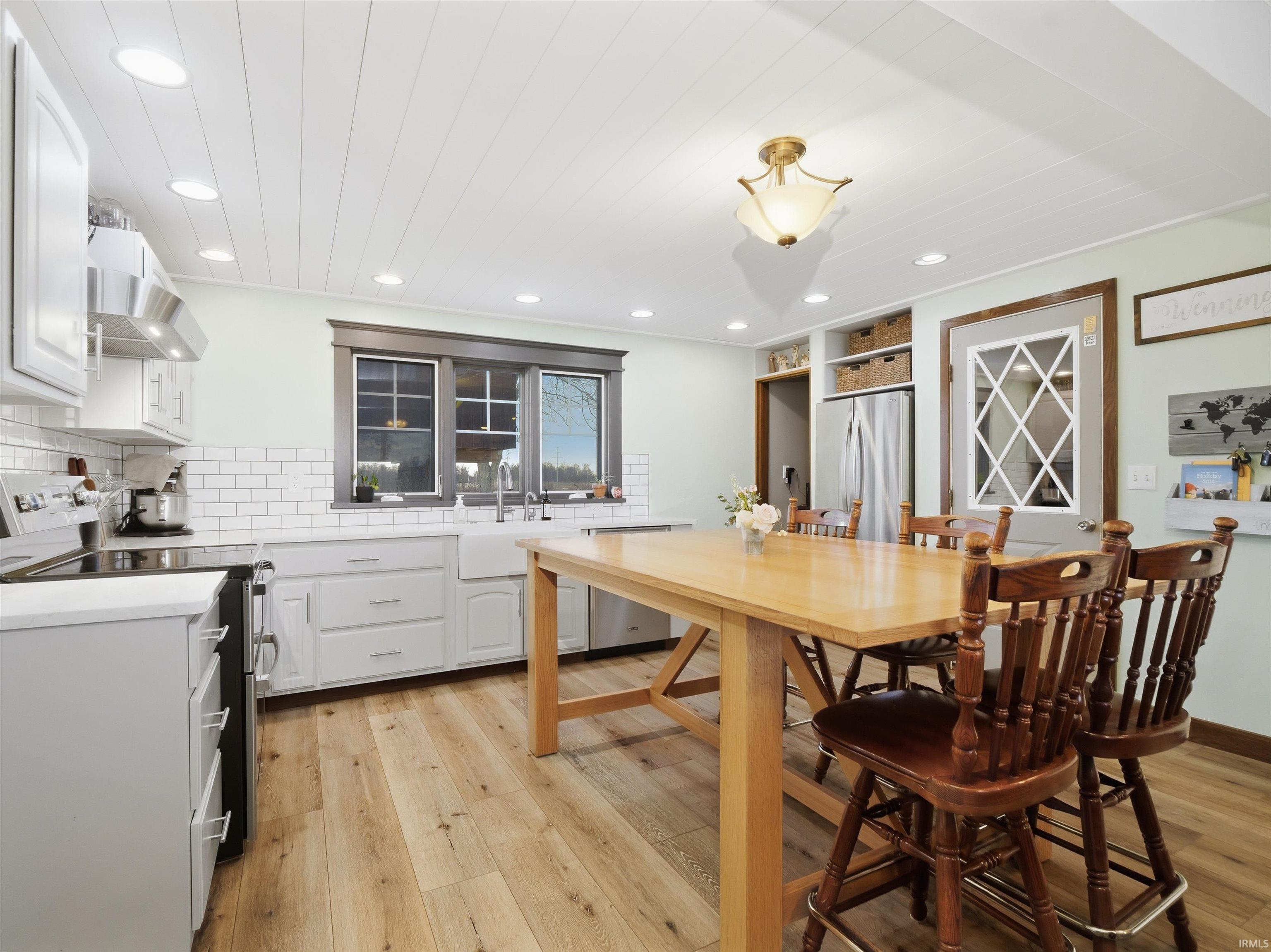 Dining space with light wood finished floors, recessed lighting, and ship-lap ceiling