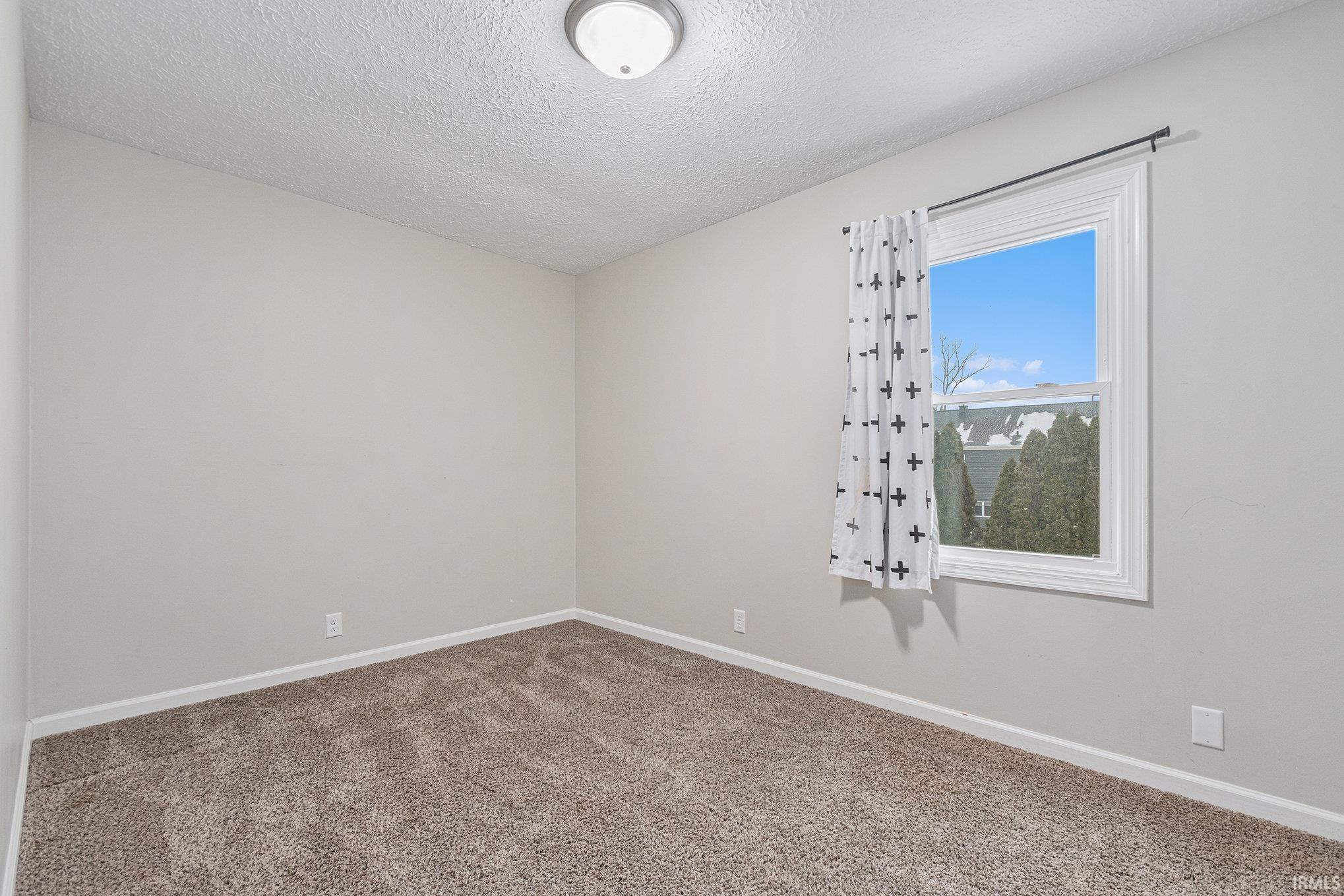 Unfurnished room with carpet flooring and a textured ceiling