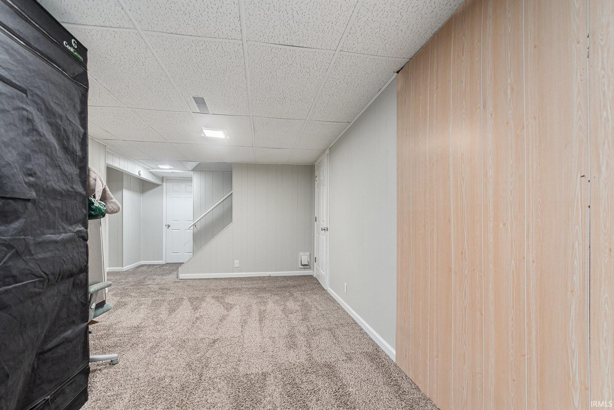 Finished basement featuring light carpet and a drop ceiling