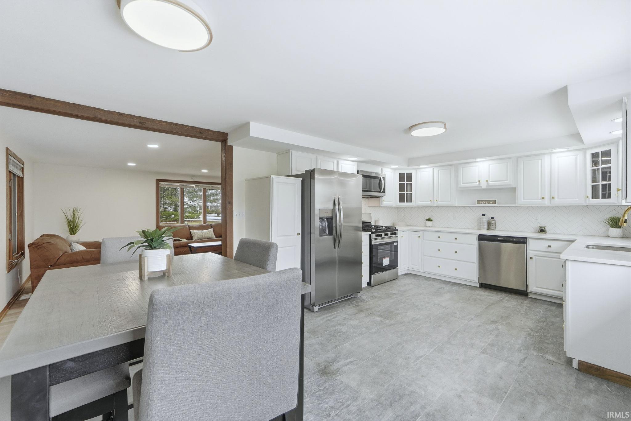 Kitchen featuring stainless steel appliances, glass insert cabinets, white cabinetry, and recessed lighting