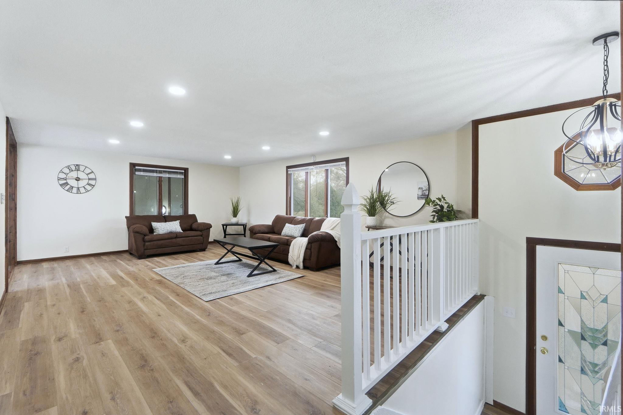 Living area featuring recessed lighting, light wood-style floors, and a chandelier