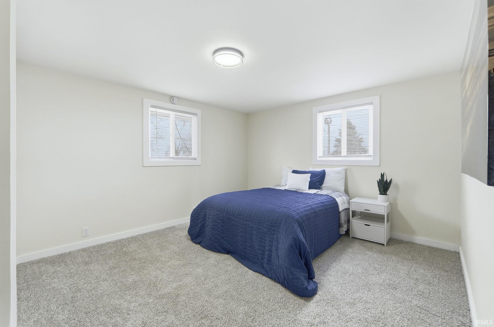 Bedroom featuring carpet floors and multiple windows