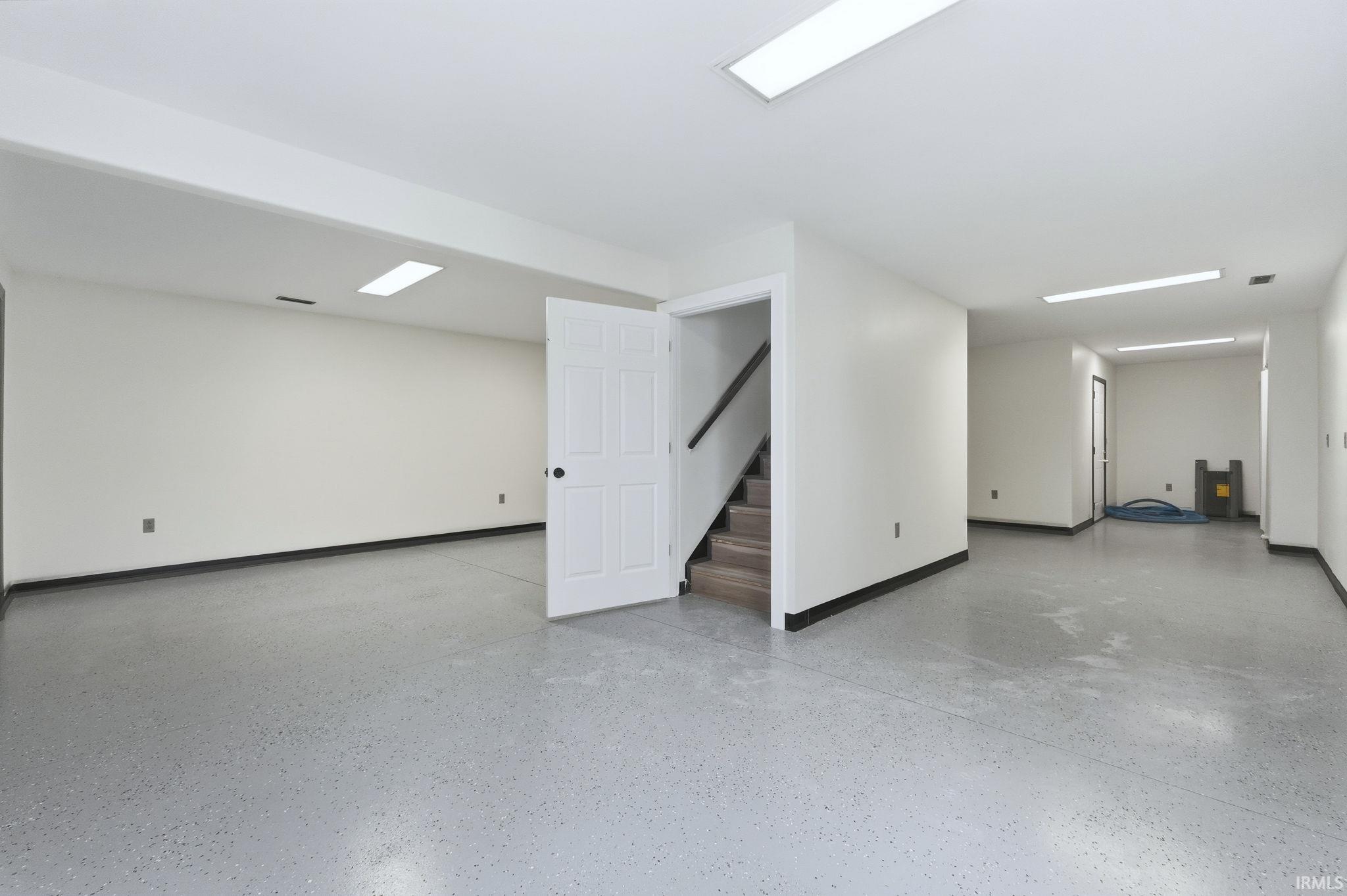 Finished below grade area featuring baseboards and stairway