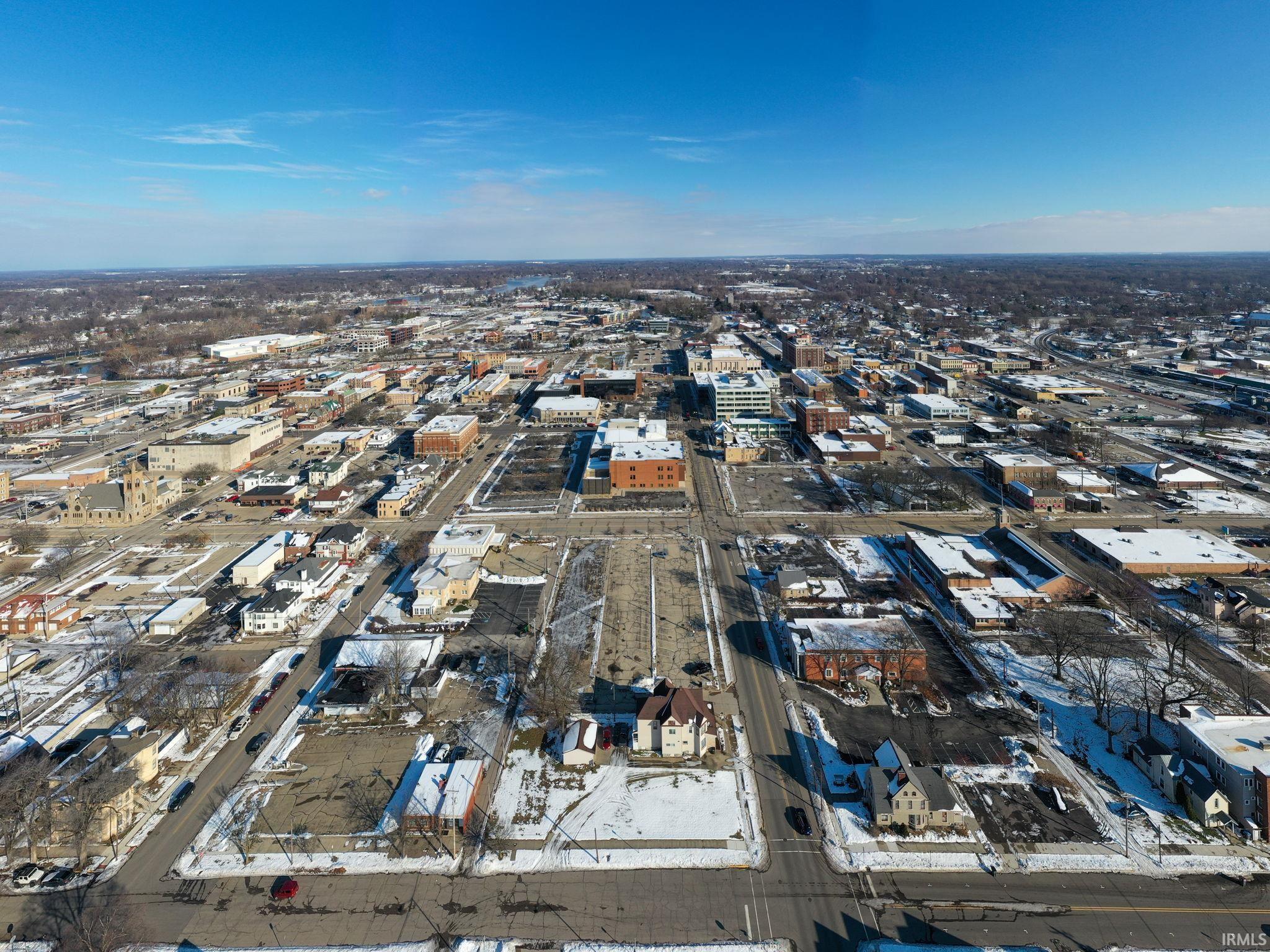 Aerial view of property and surrounding area with nearby urban area