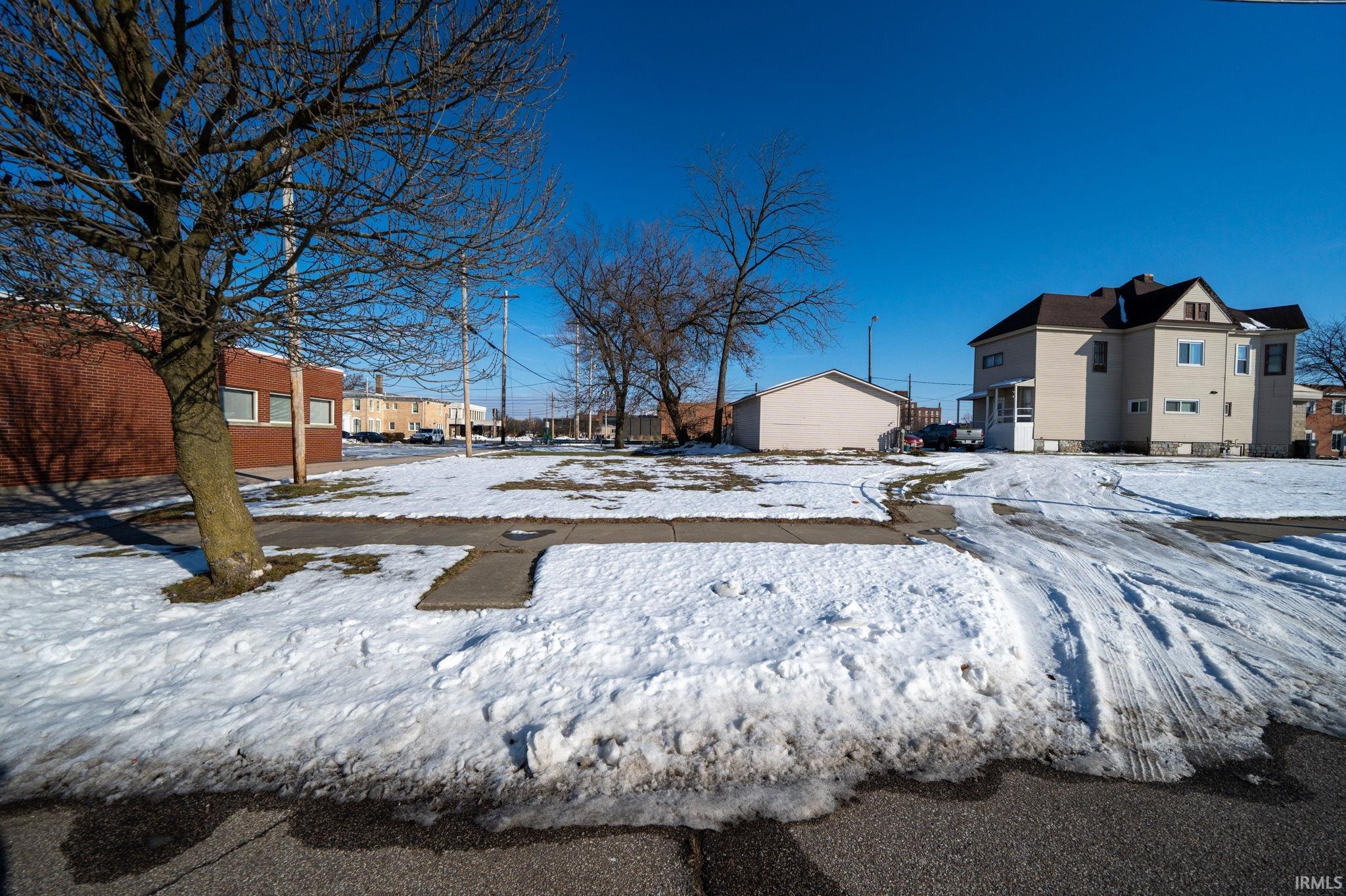 Yard layered in snow with a residential view