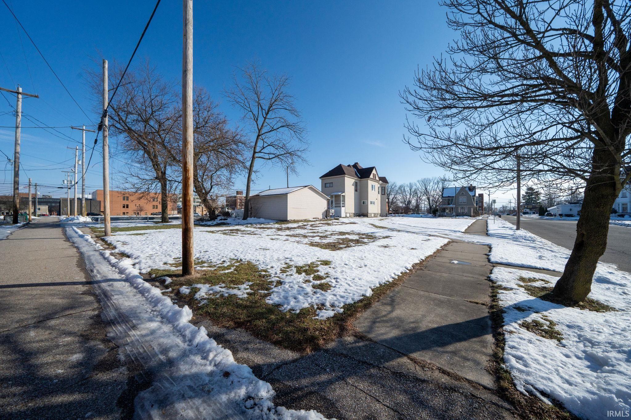 Snowy yard featuring a residential view