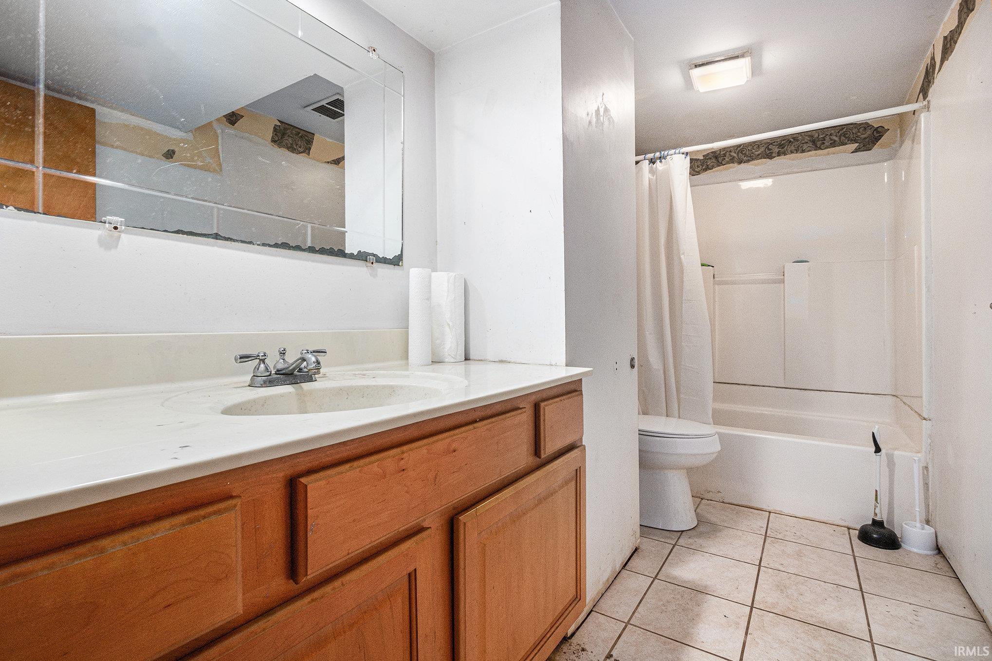 Bathroom with vanity, shower / bath combo, and light tile patterned floors