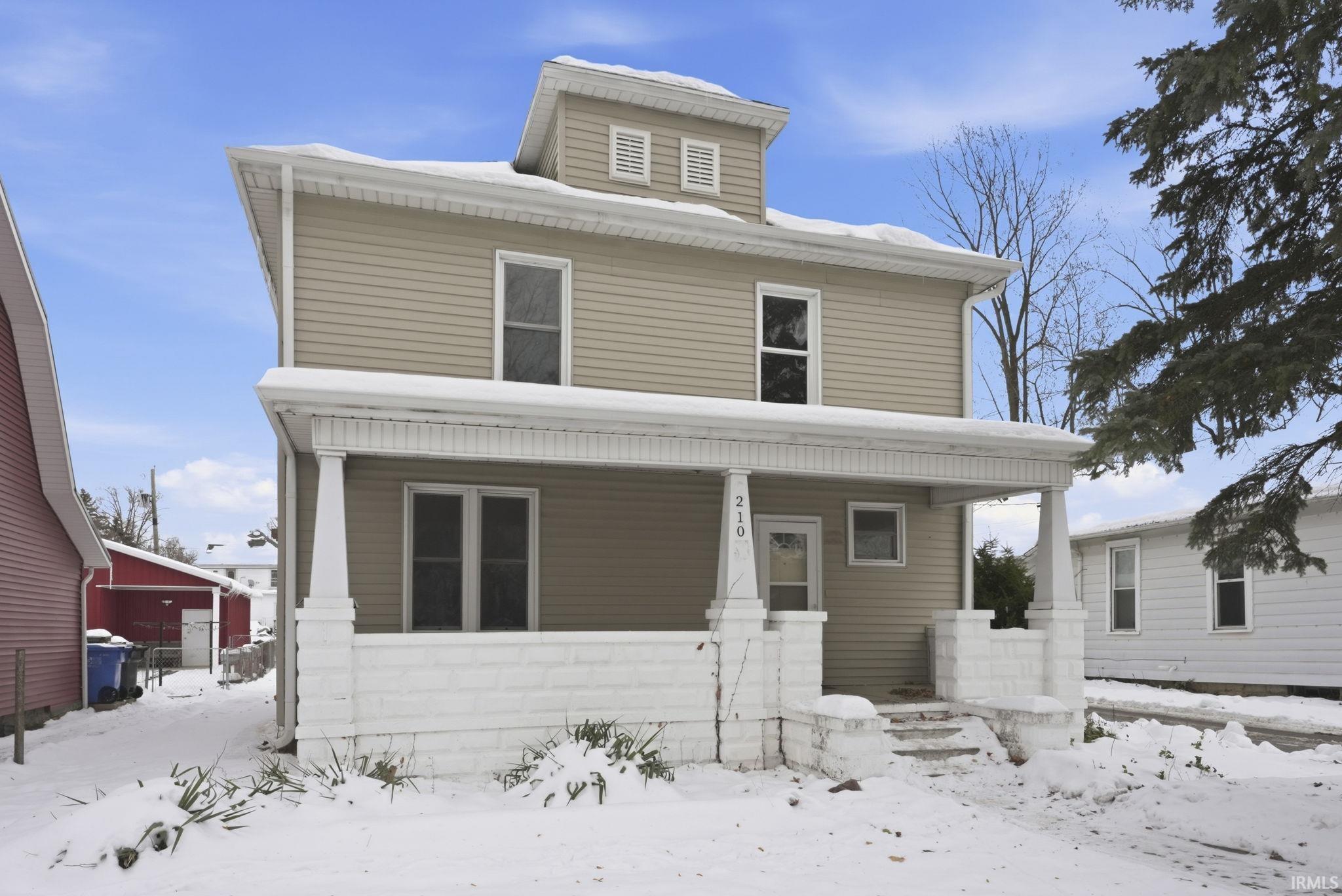 American foursquare style home featuring a porch