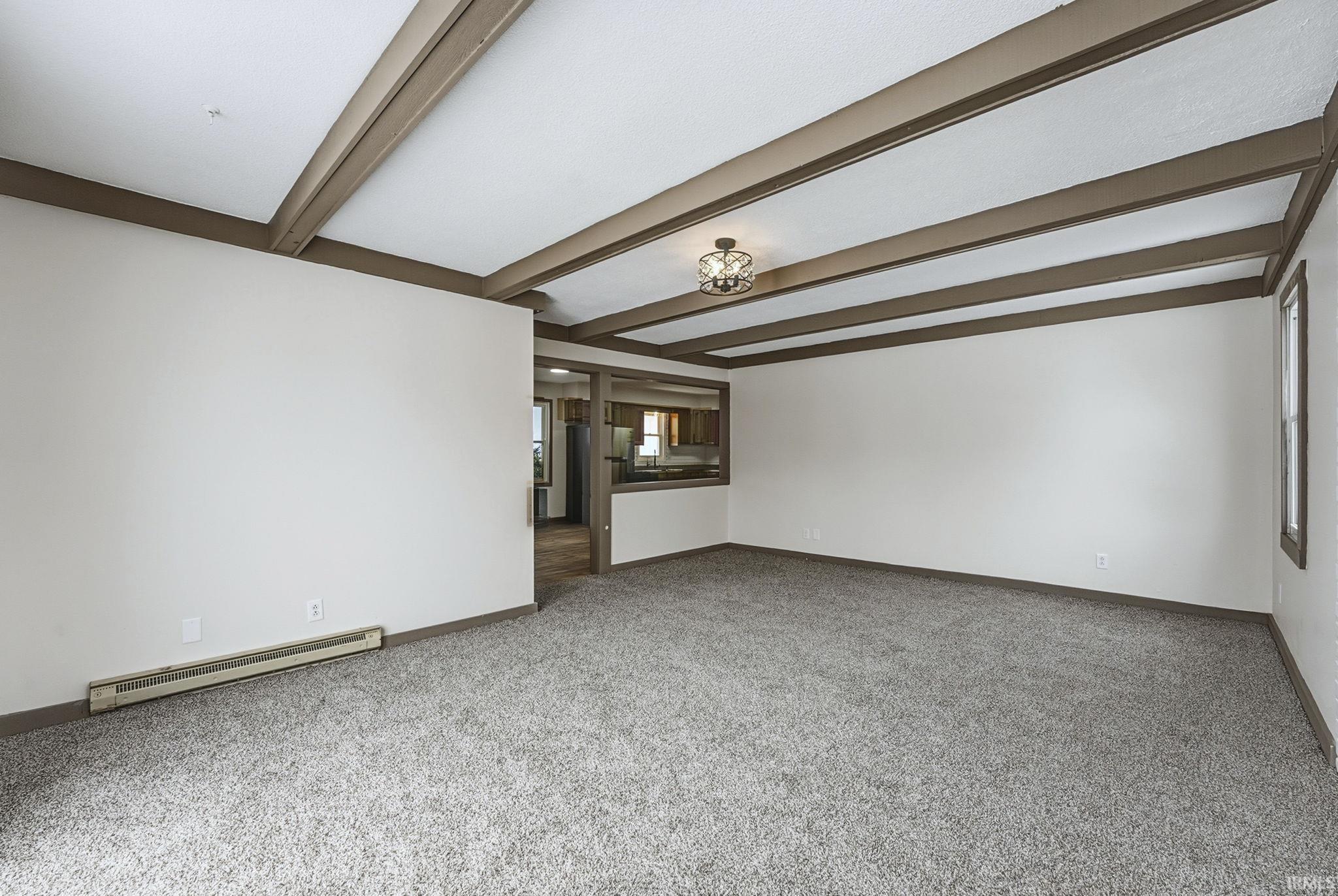 Unfurnished living room with baseboard heating and light carpet