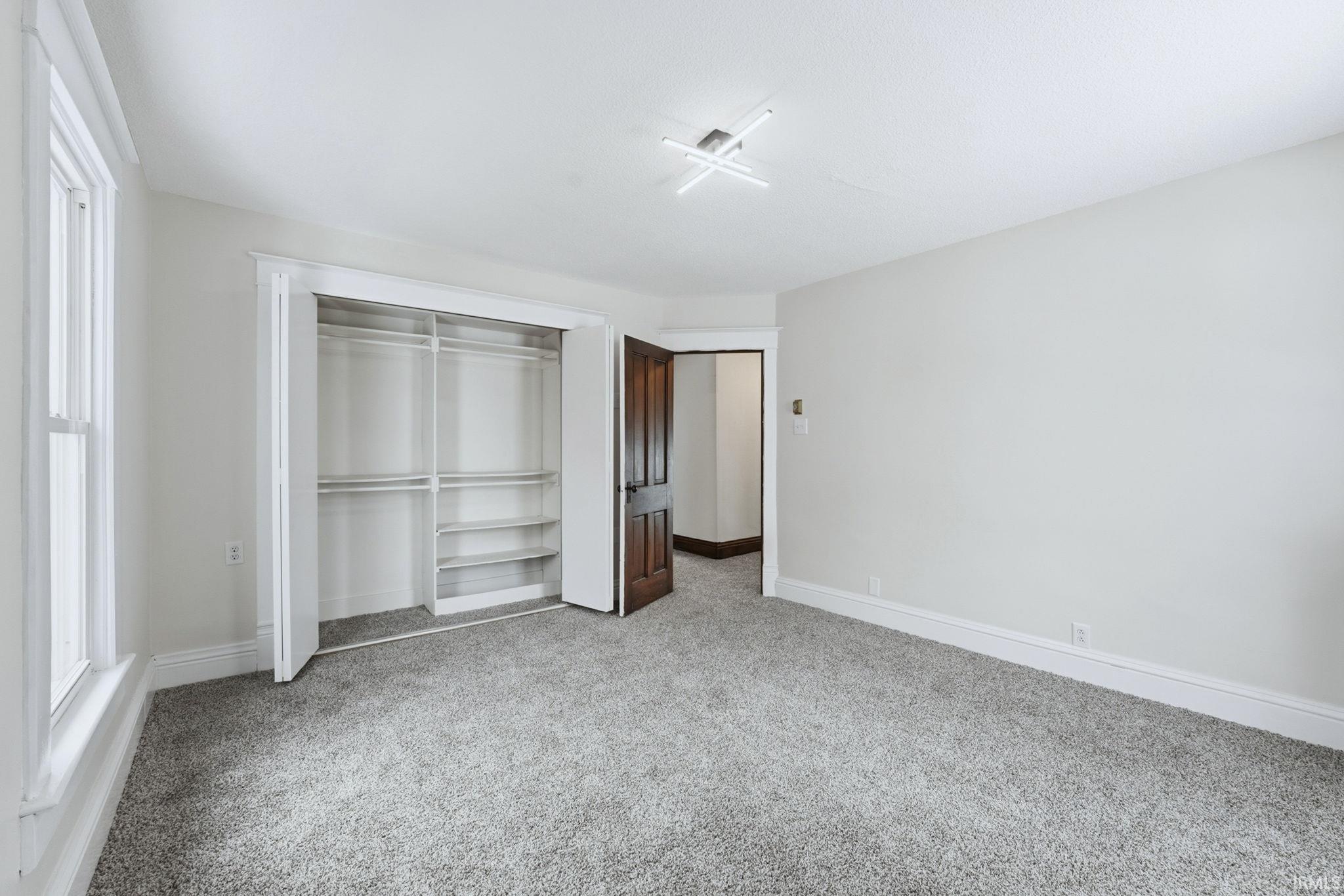 Unfurnished bedroom with a closet and light colored carpet