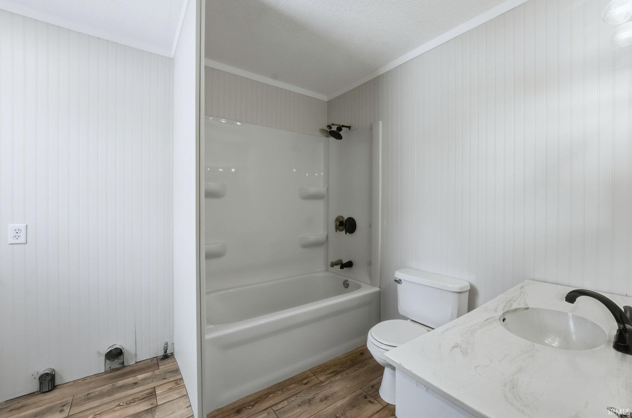 Full bath featuring light wood finished floors, vanity, shower / tub combination, and crown molding