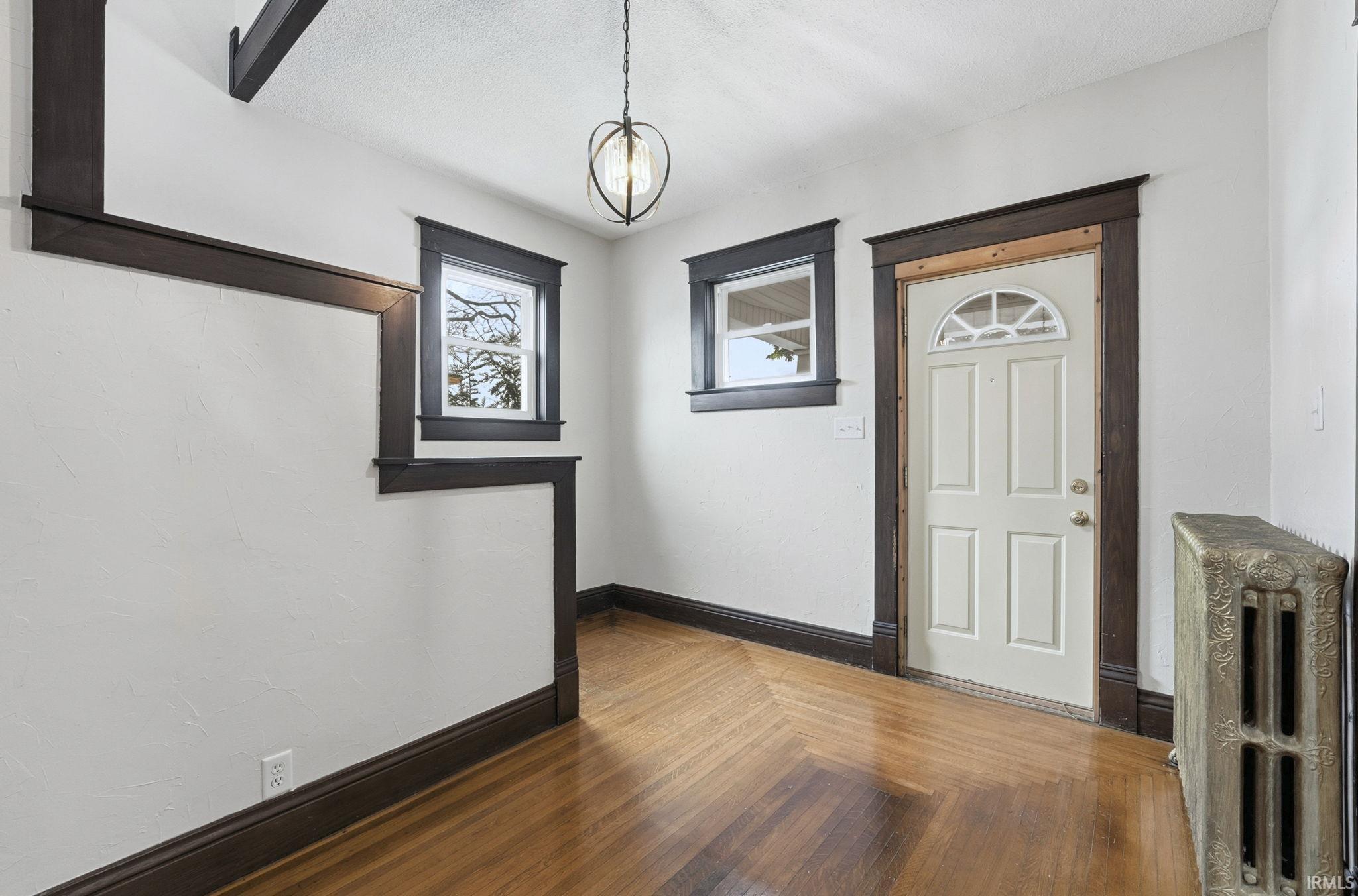 Entrance foyer featuring radiator and dark wood-style flooring