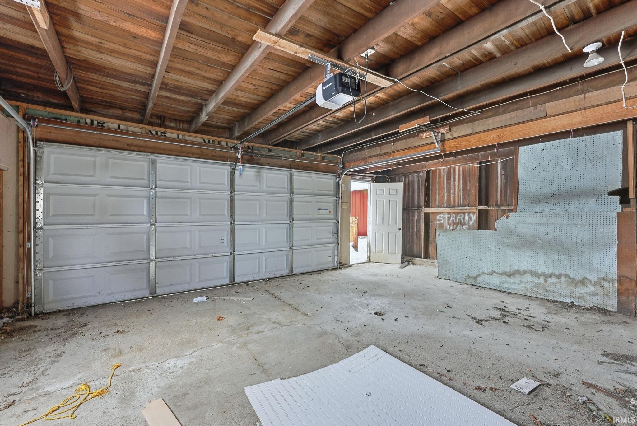 Garage featuring wood ceiling and a garage door opener