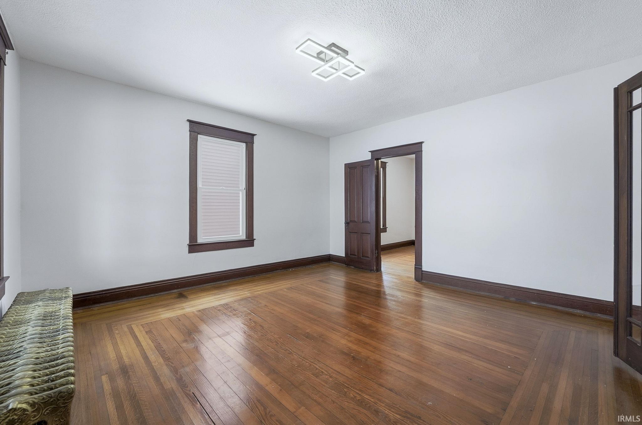 Spare room with dark wood-type flooring and a textured ceiling