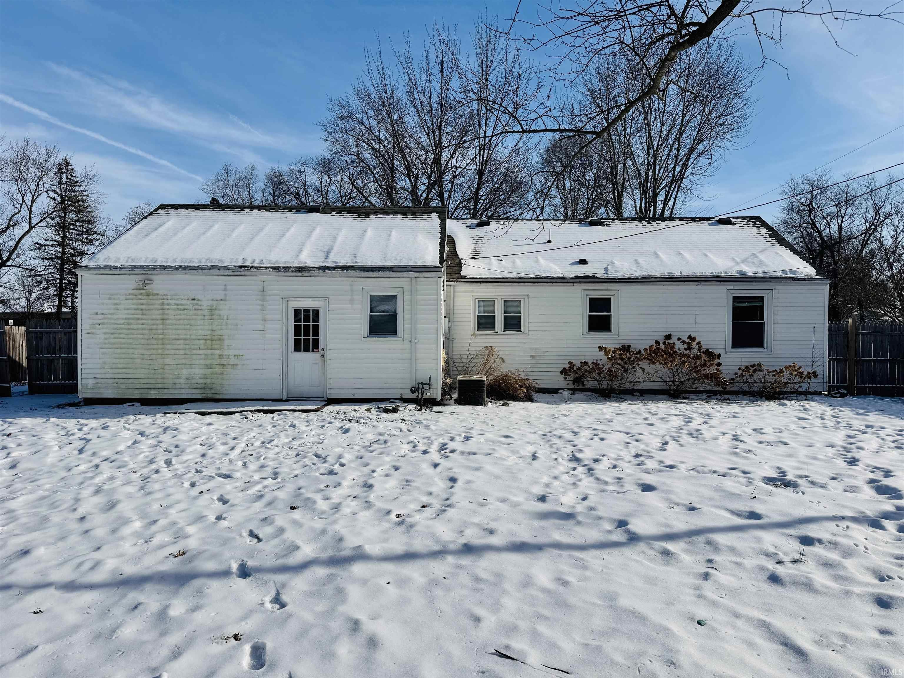 View of snow covered back of property