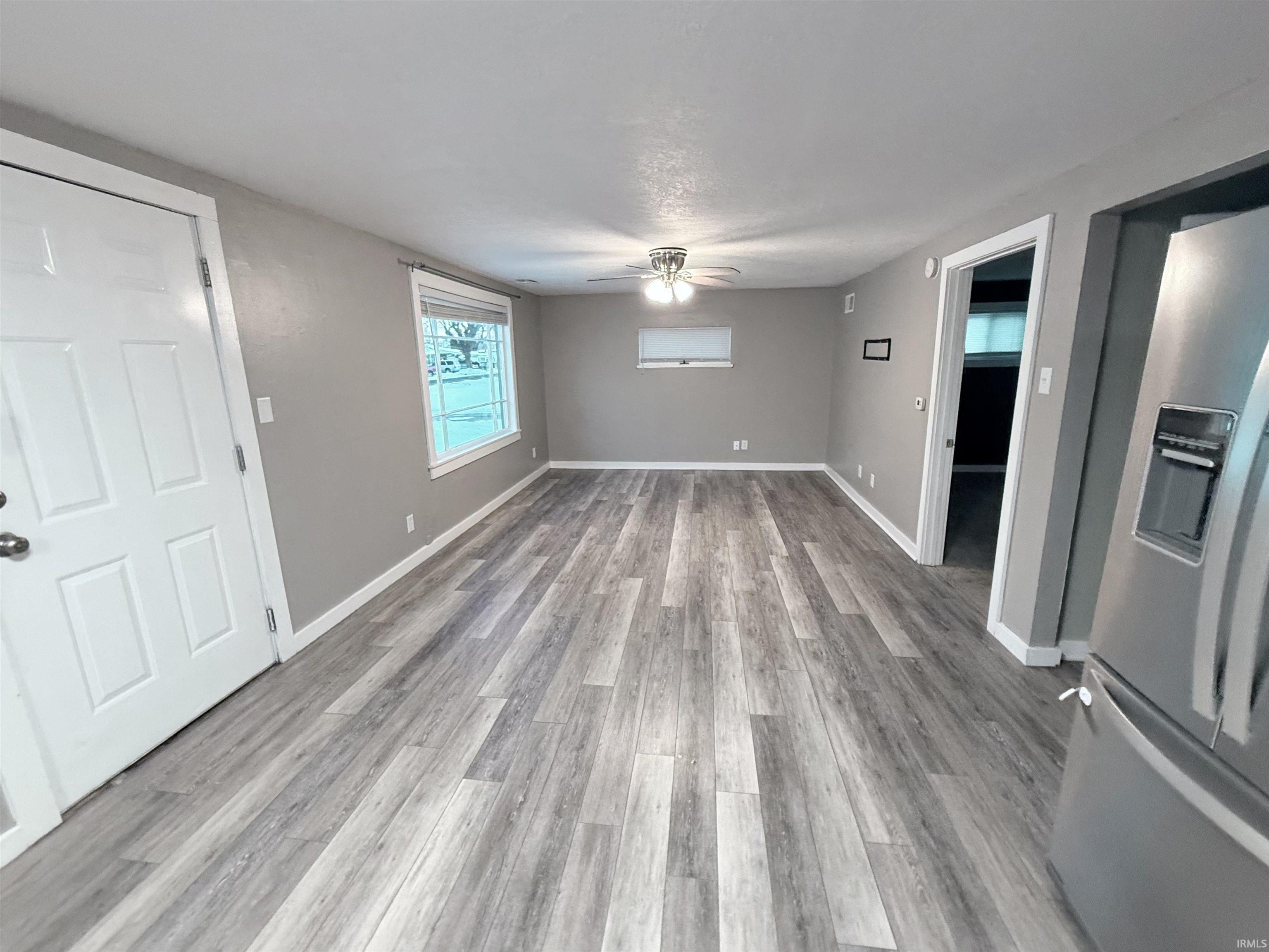 Unfurnished living room featuring ceiling fan and light wood finished floors