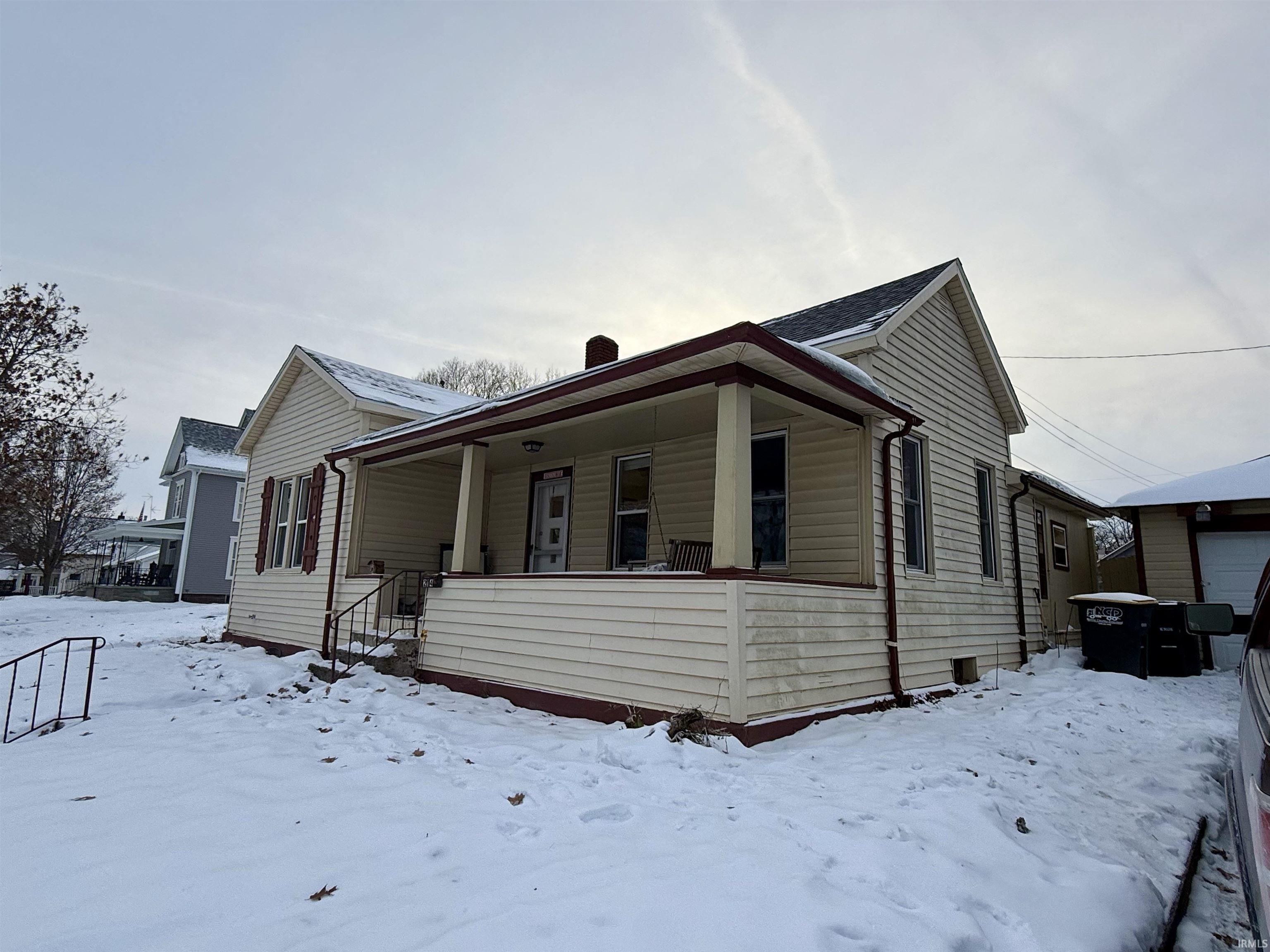 View of front of home with covered porch and a chimney